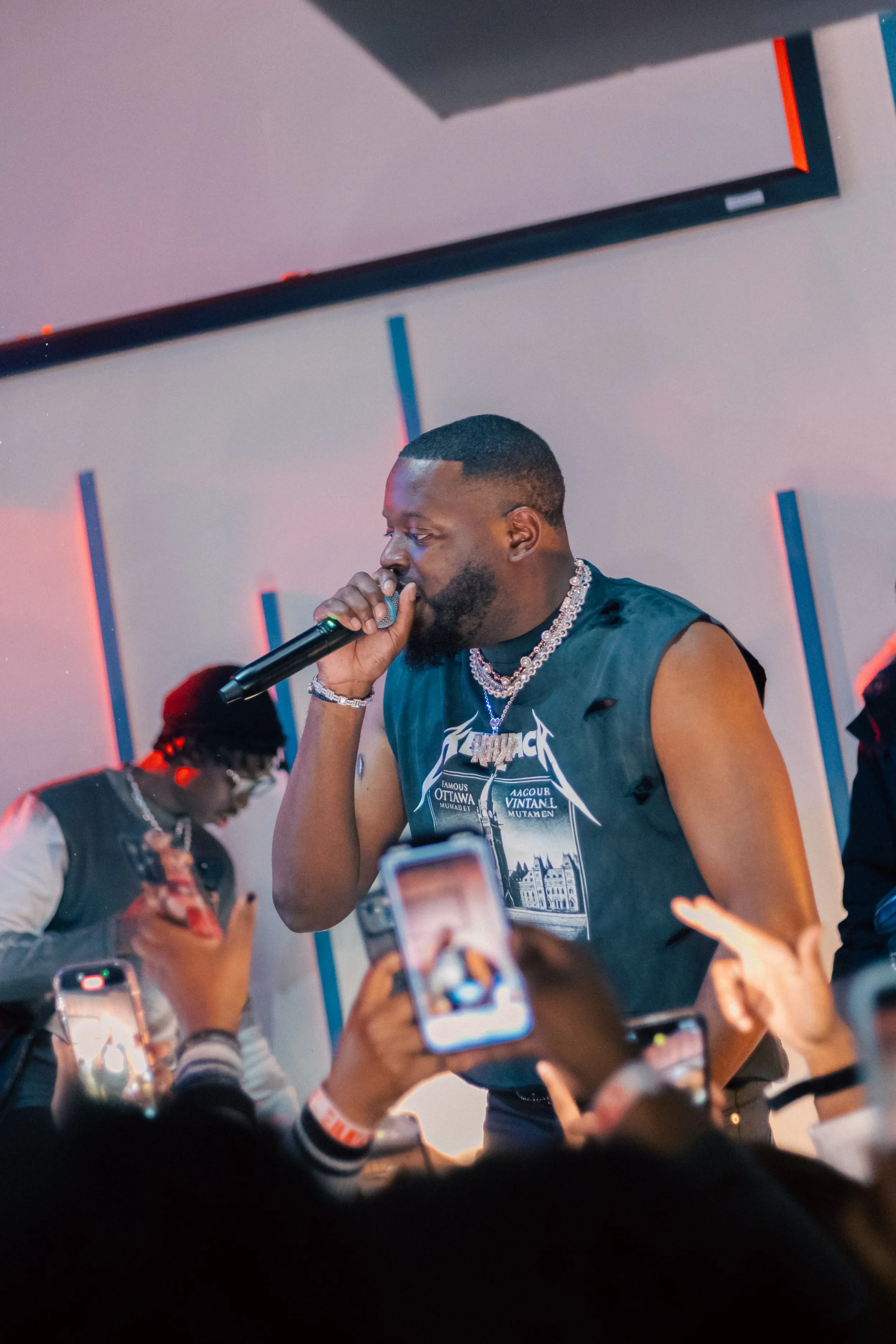 Side-angle cinematic performance photo of an artist during a live showcase, capturing movement, energy, and stage presence.