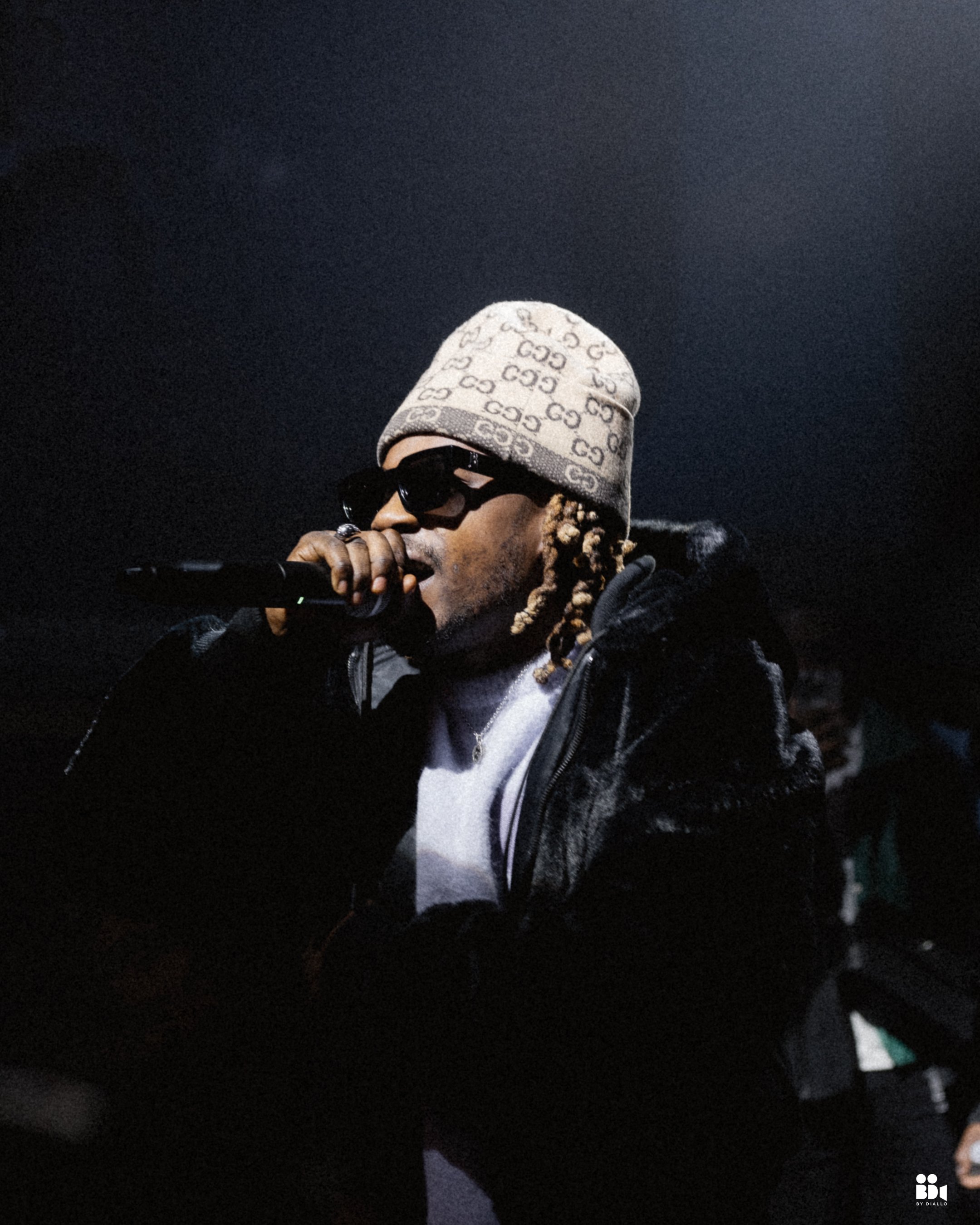 Moody cinematic photo of an artist on stage during a live showcase, using dramatic lighting and negative space for visual impact.