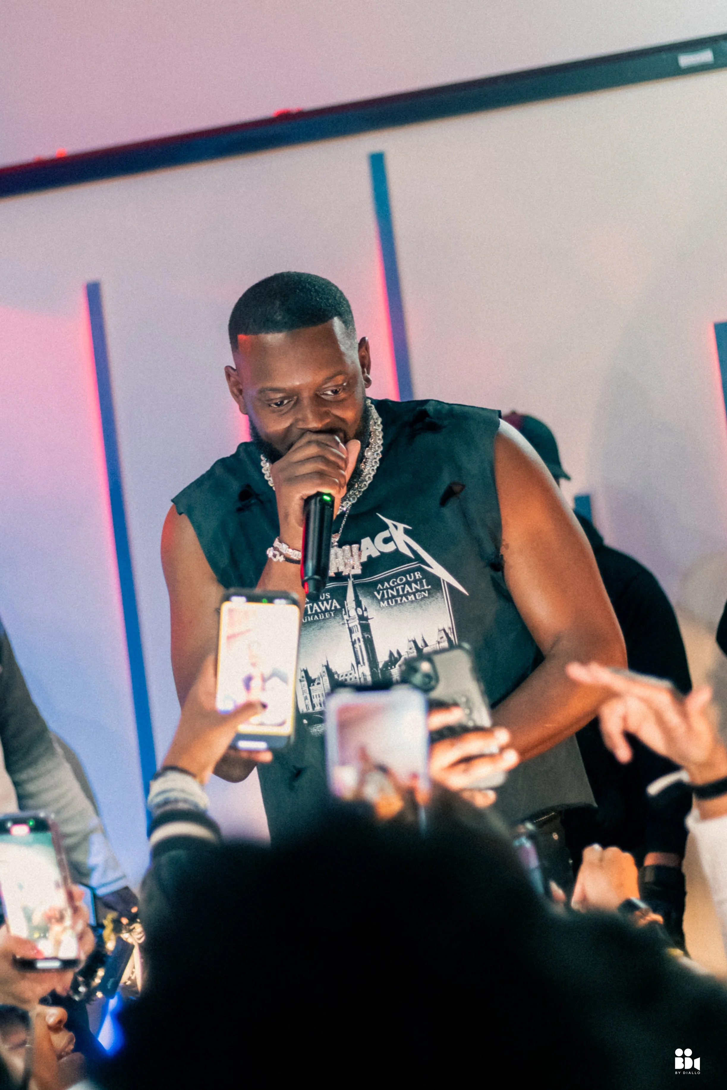 Cinematic photo of an artist performing live on stage in Ottawa, with the crowd capturing the moment during a showcase event.