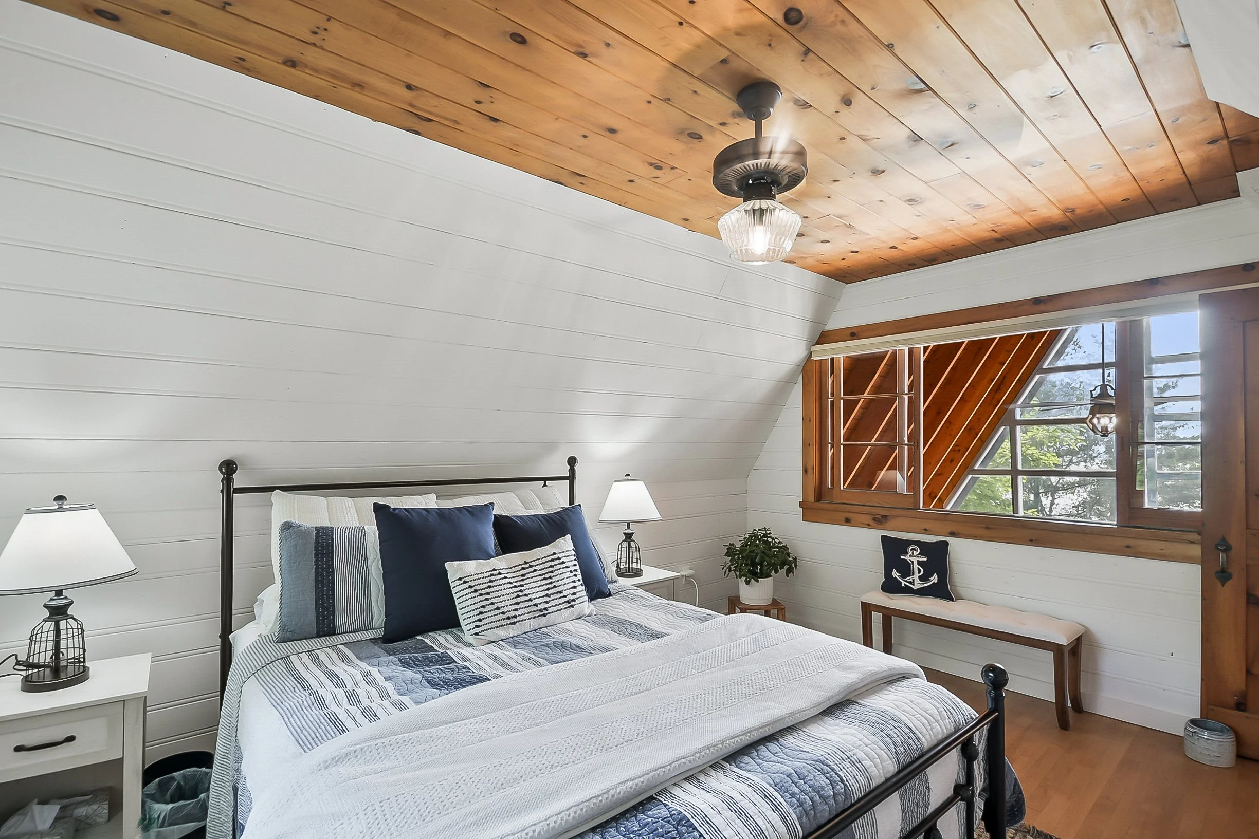 The Blue Room: Queen bed with shared bath on the second floor in the main cottage, with forest views and a glimpse of the lake.