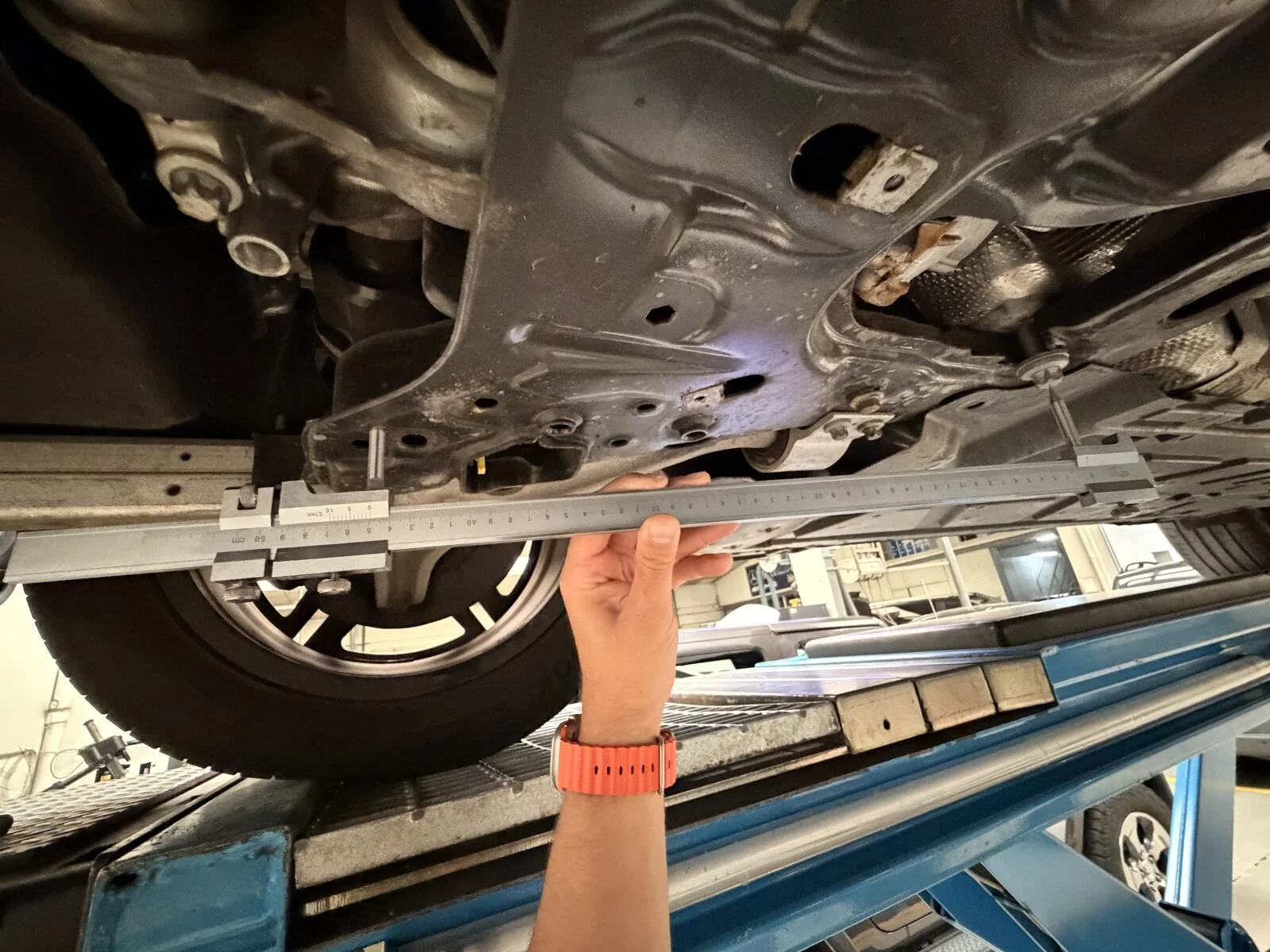 Perito midiendo los bajos de un vehículo con calibre