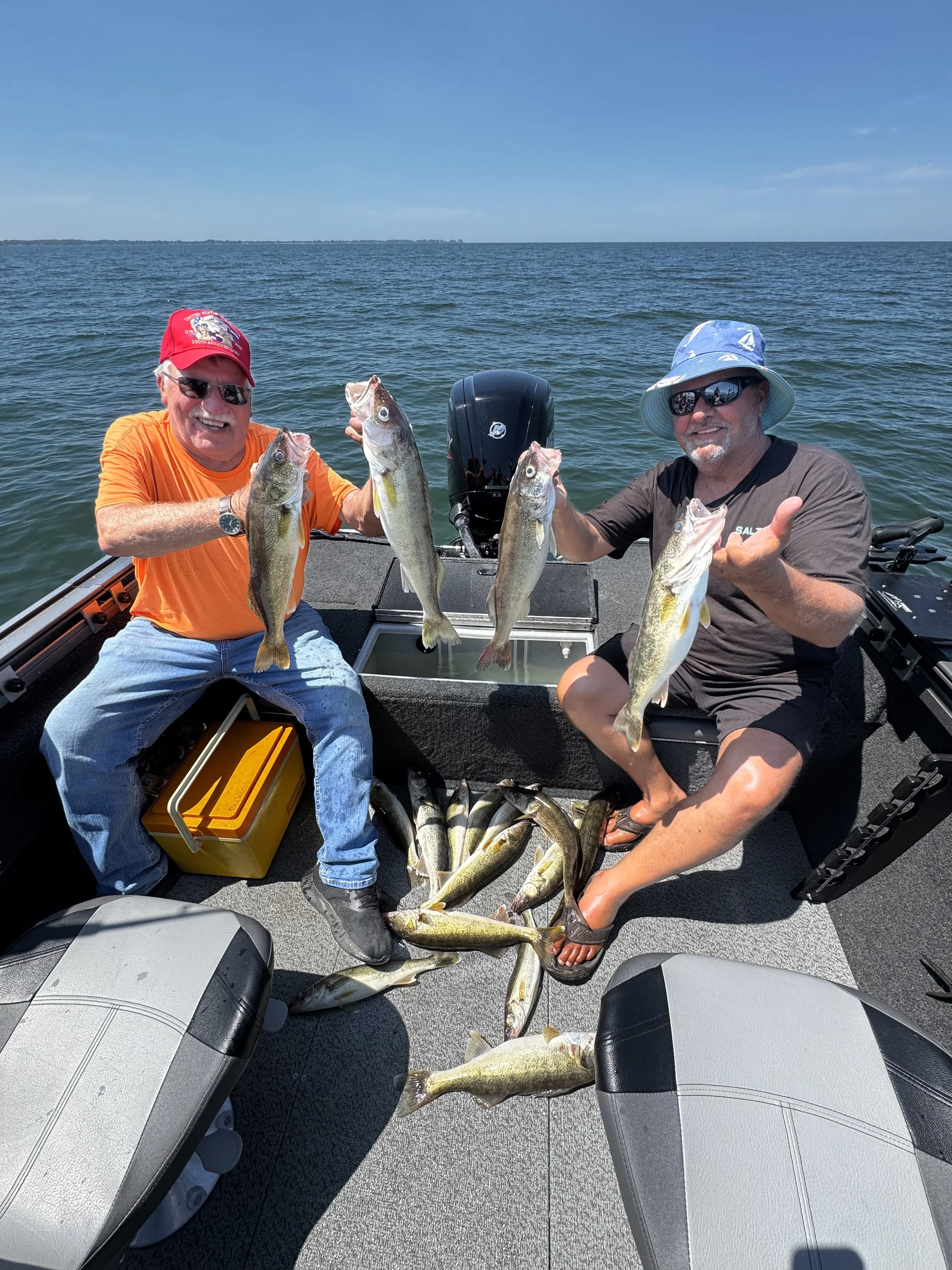 Two anglers holding Lake St. Clair walleye during a guided fishing charter with The Outdoor Conquest.