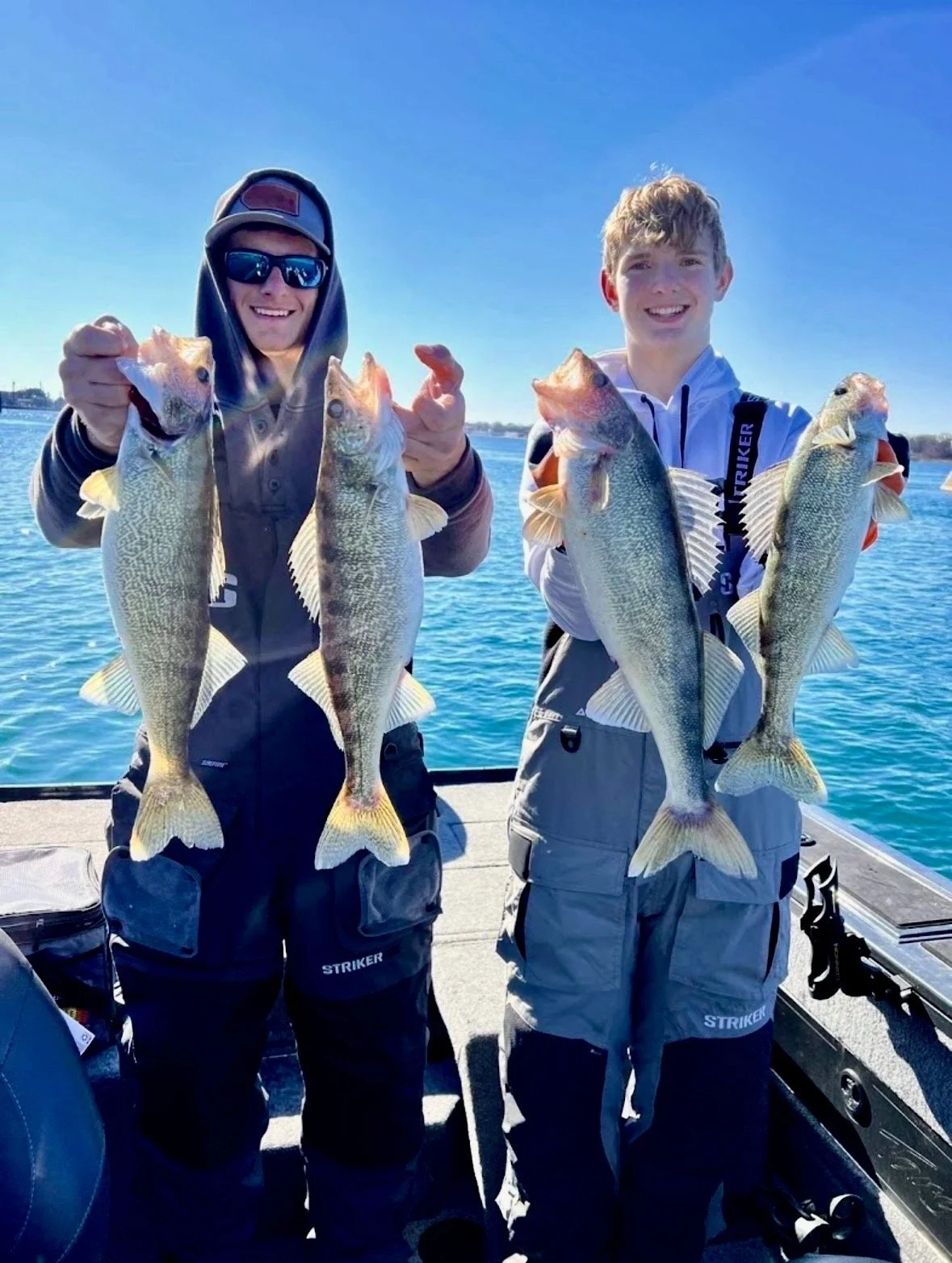 Two young anglers holding Lake St. Clair walleye during a guided fishing charter with The Outdoor Conquest.