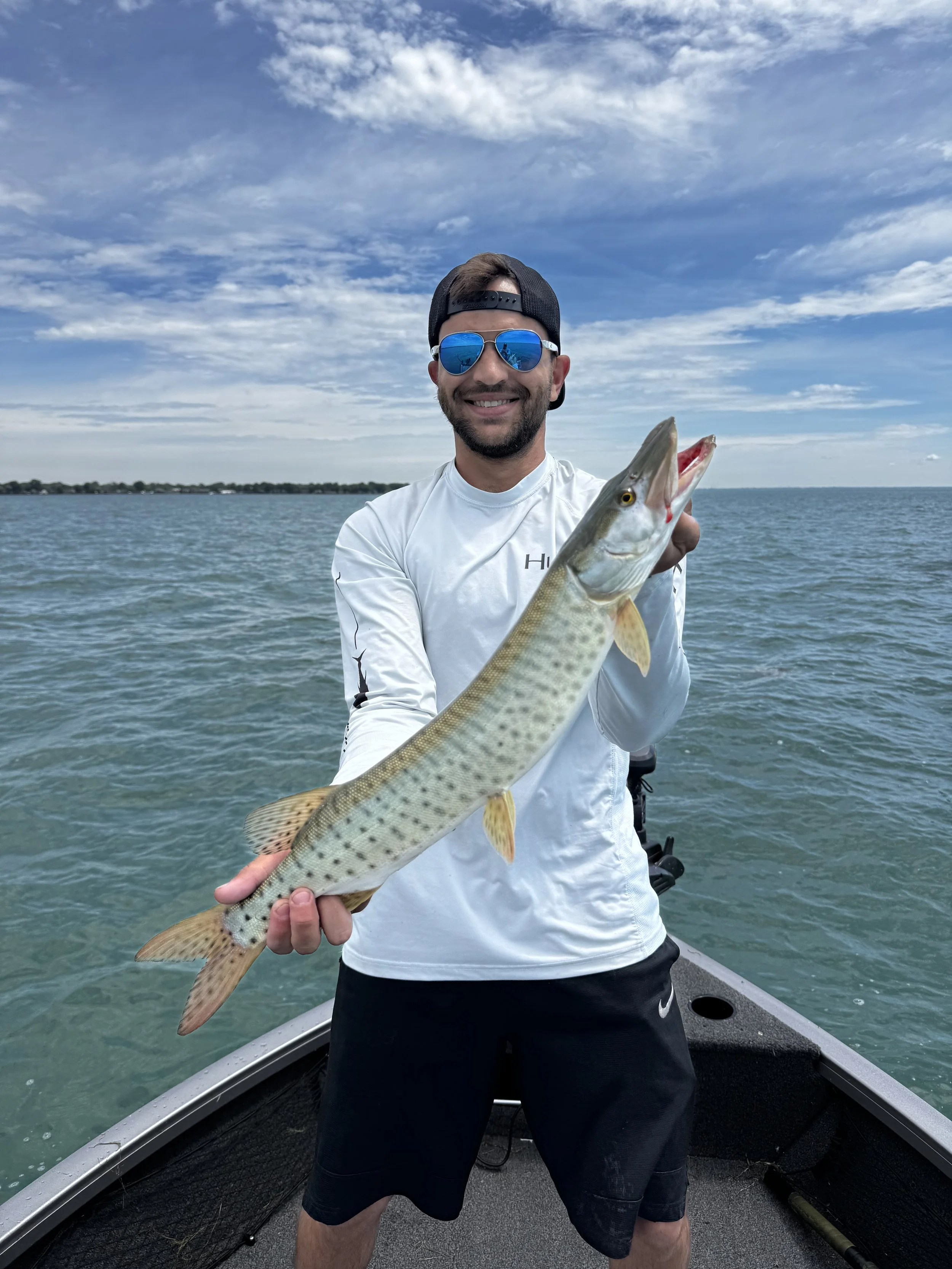 Angler holding a trophy muskie caught during a guided fishing charter on Lake St. Clair.
