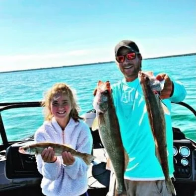 Family catching walleye on Lake St. Clair during guided fishing charter