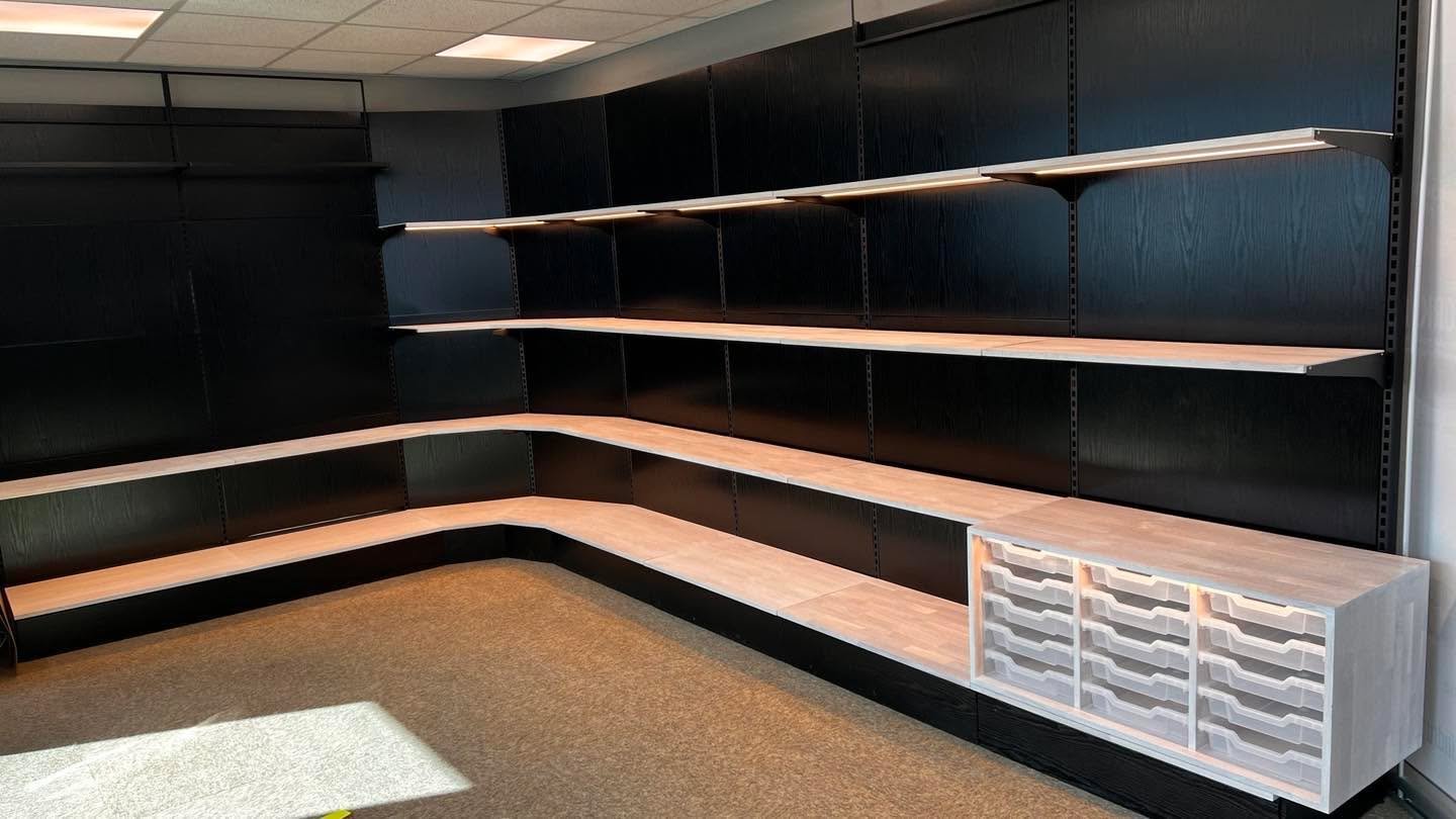 Renovering av Hestra butikkinnredning. Bakvegger i st&aring;l er foliert med svart treimitert folie. Stolper og hylle knekter er lakkert i svart matt. Hyller er lager i 18mm eik. Med innfelt ALU LED skinner. Og skuffeseksjon for transparange skuffer.