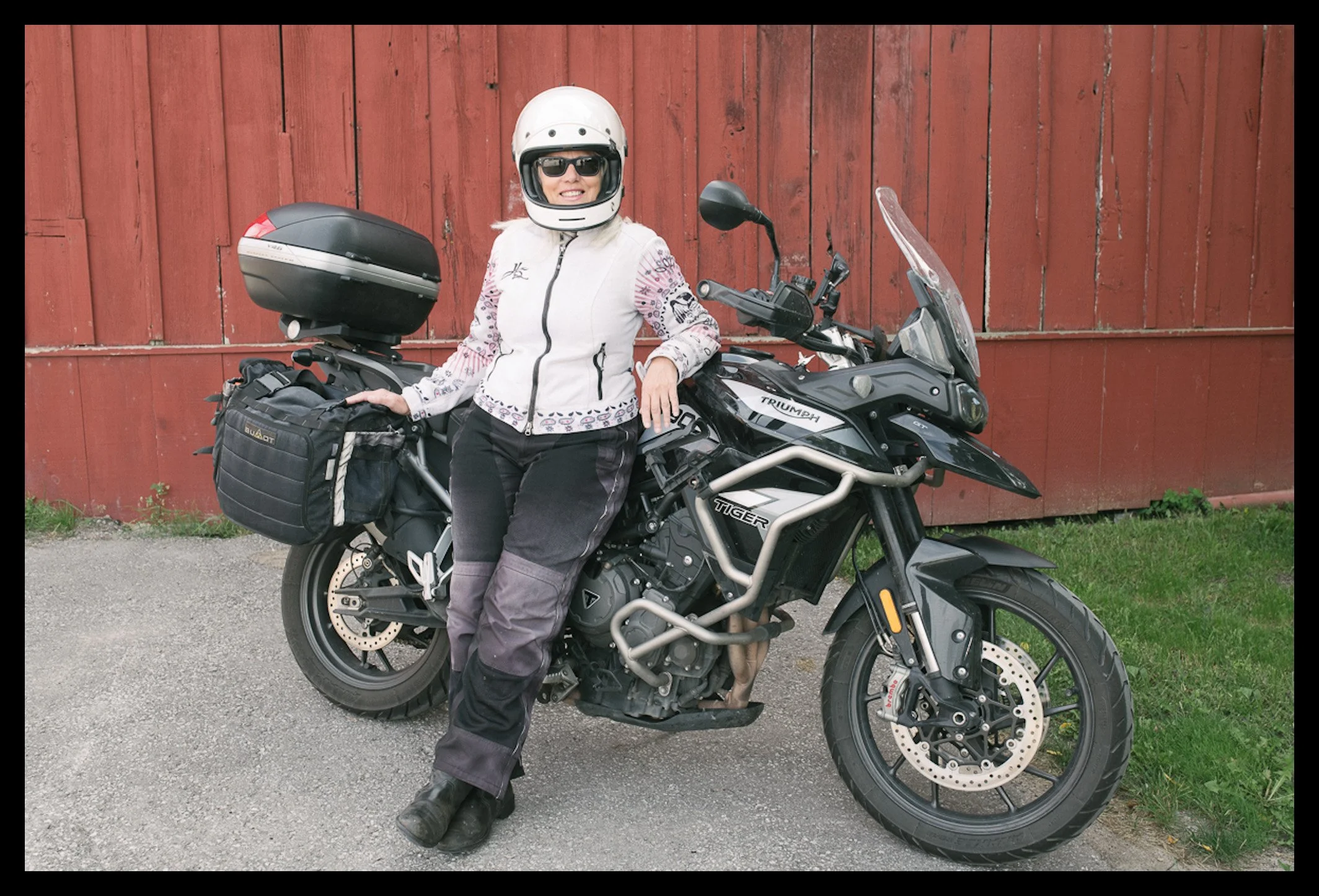 female motorcycle adventure rider portrait in natural light with Triumph Tiger motorcycle
