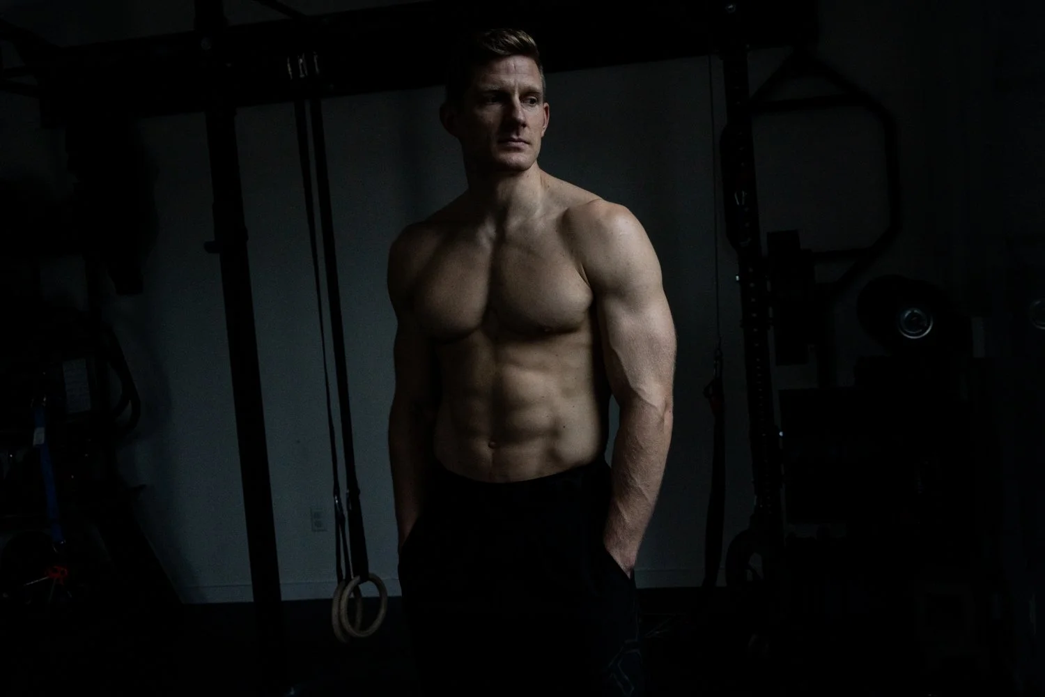 Natural light portrait of muscled crossfit athlete brent fikowski  side window light to create dramatic shadow and mood in colour  