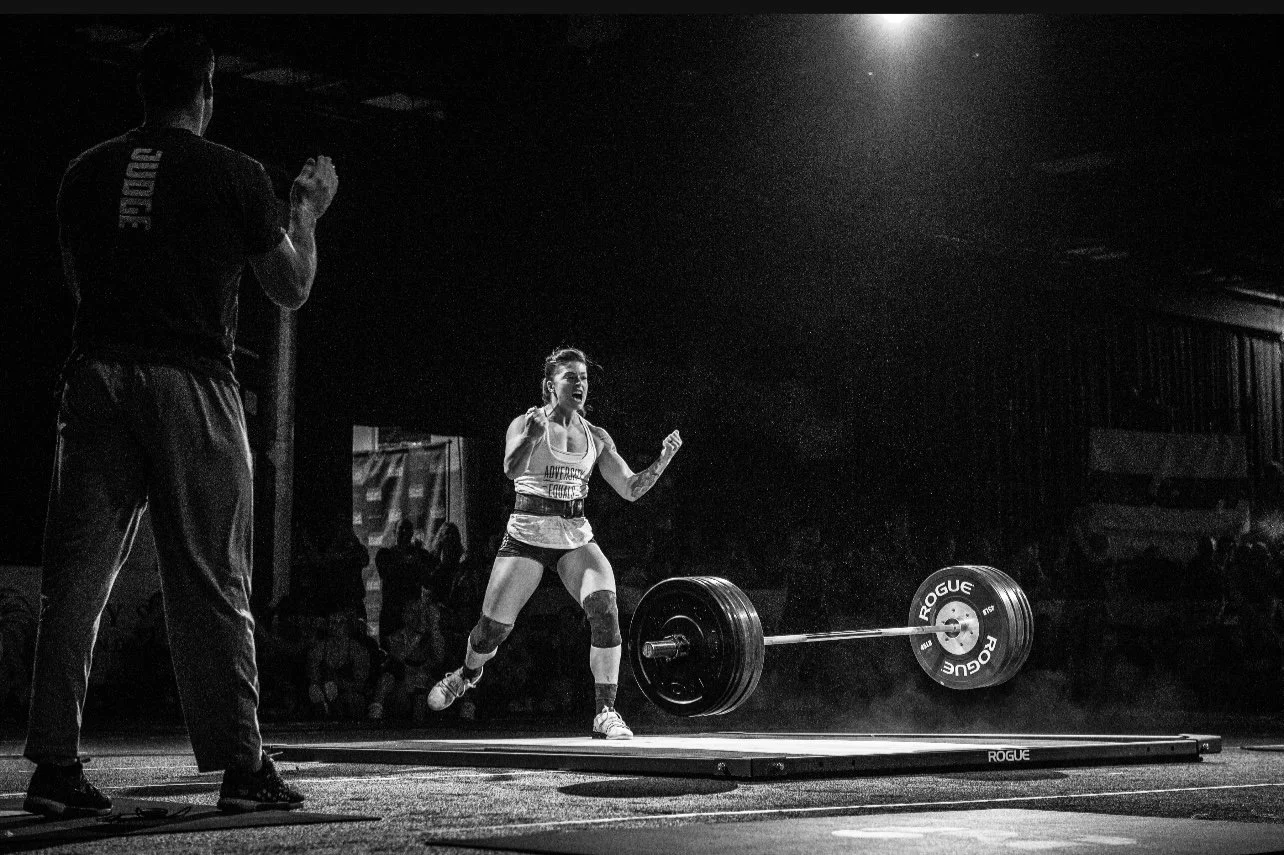 victory editorial magazine shoot of athletic woman celebrating after olympic lift crossfit barbell bouncing. moody over head light victorious athlete 