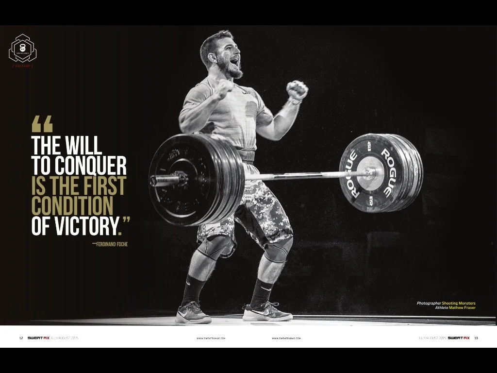 Mat Fraser professional crossfit athlete nike sponsored olympic lifter celebrating after win. barbell bouncing overhead moody light to create shadow fist pumping win. editorial piece for magazine 