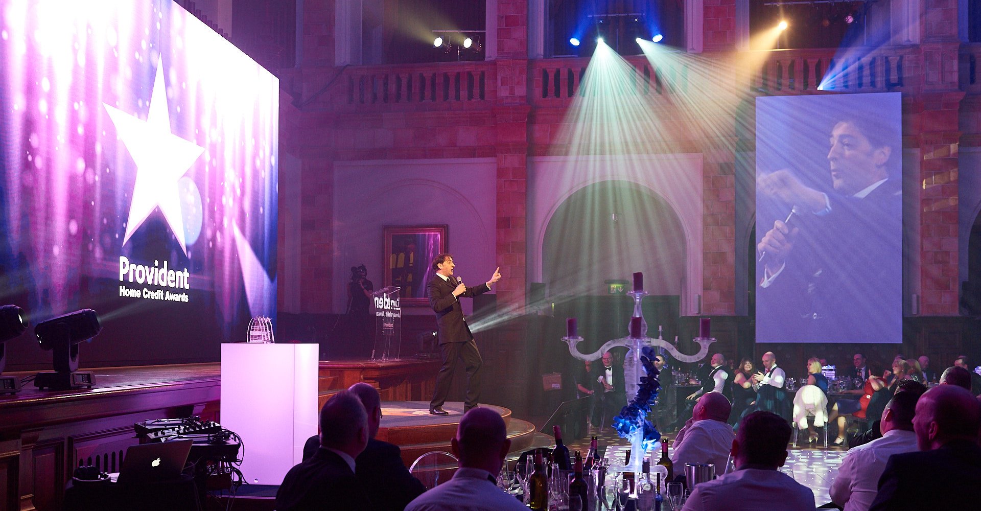 Corporate event stage with LED screen and lighting effects