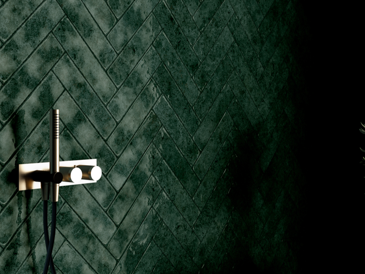 Dark green tiled wall with a modern wall-mounted shower fixture with a handheld showerhead.