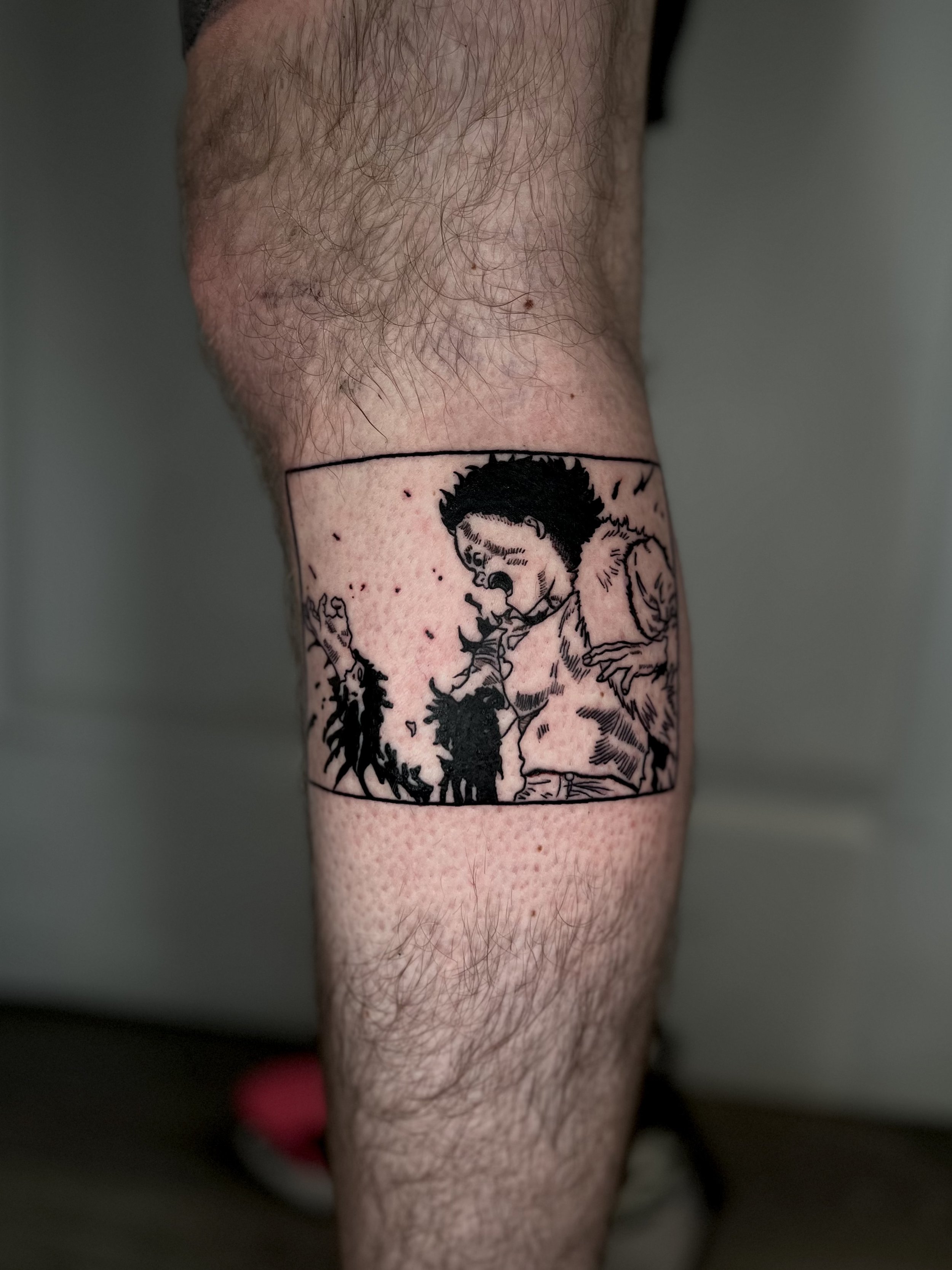 Black ink tattoo of a person and a dog on a person's lower leg.