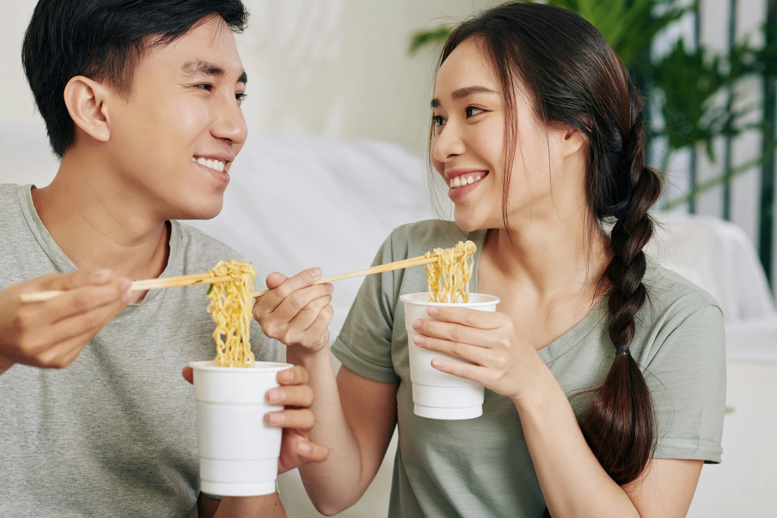 Happy couple slurping noodles after successfully using medications and exposure therapy to treat misophonia