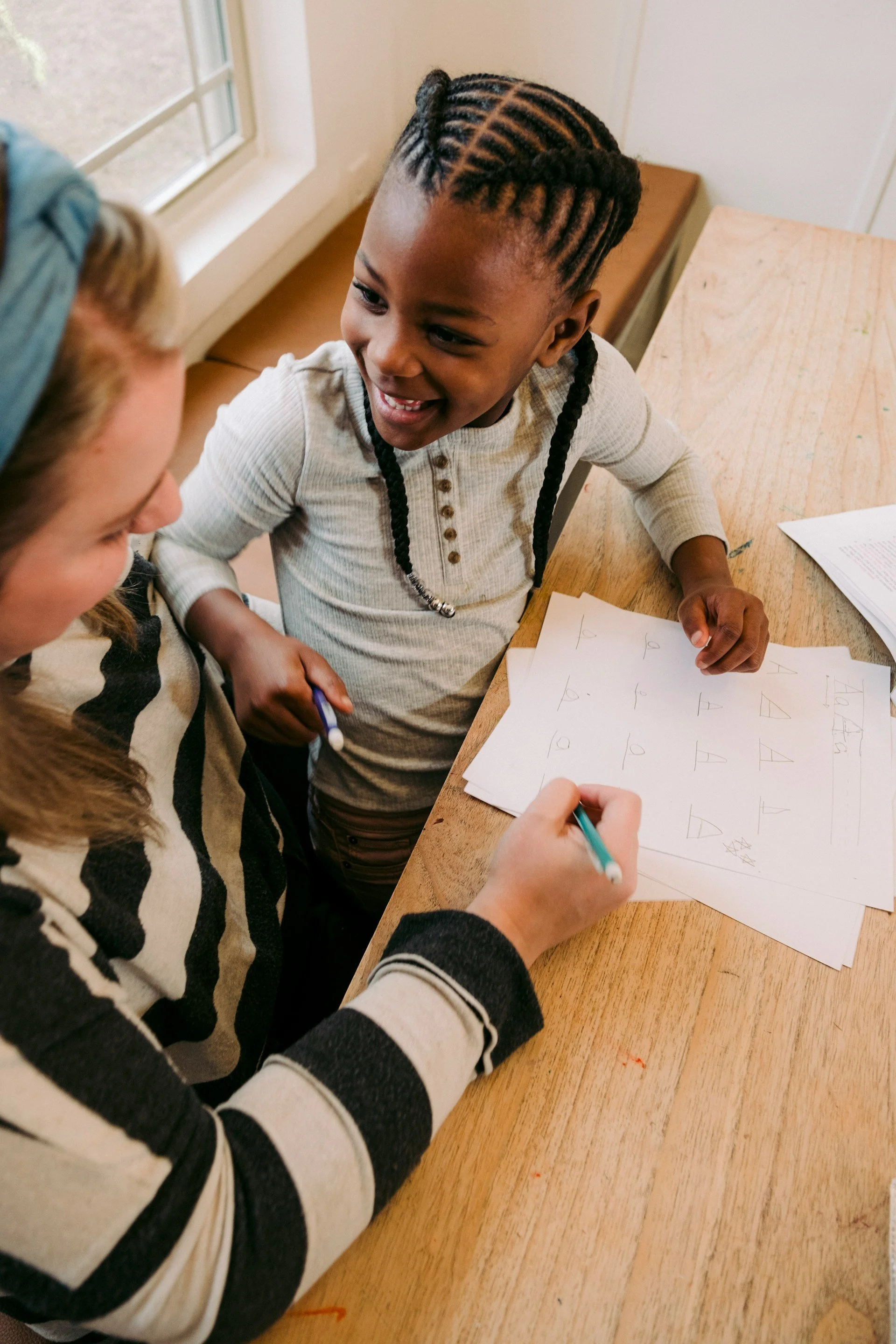 Child and mother smiling while doing homework together during ADHD support and treatment in Ogden Utah