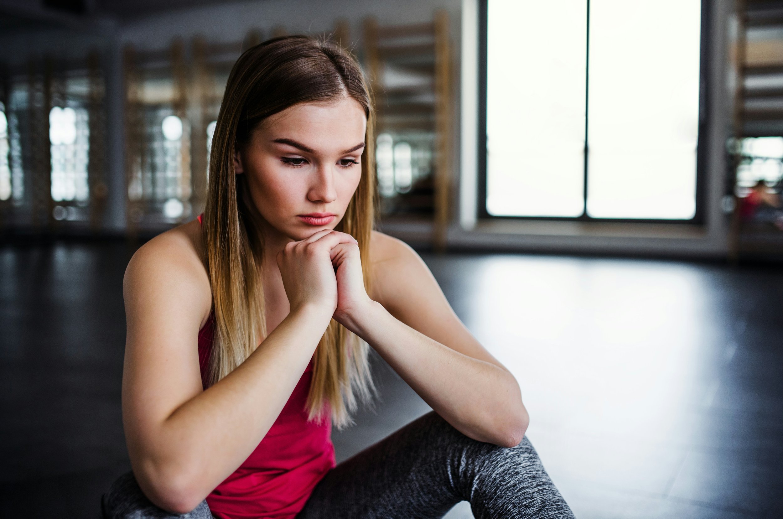 Woman reflecting at the gym while working toward recovery from depression in Ogden Utah