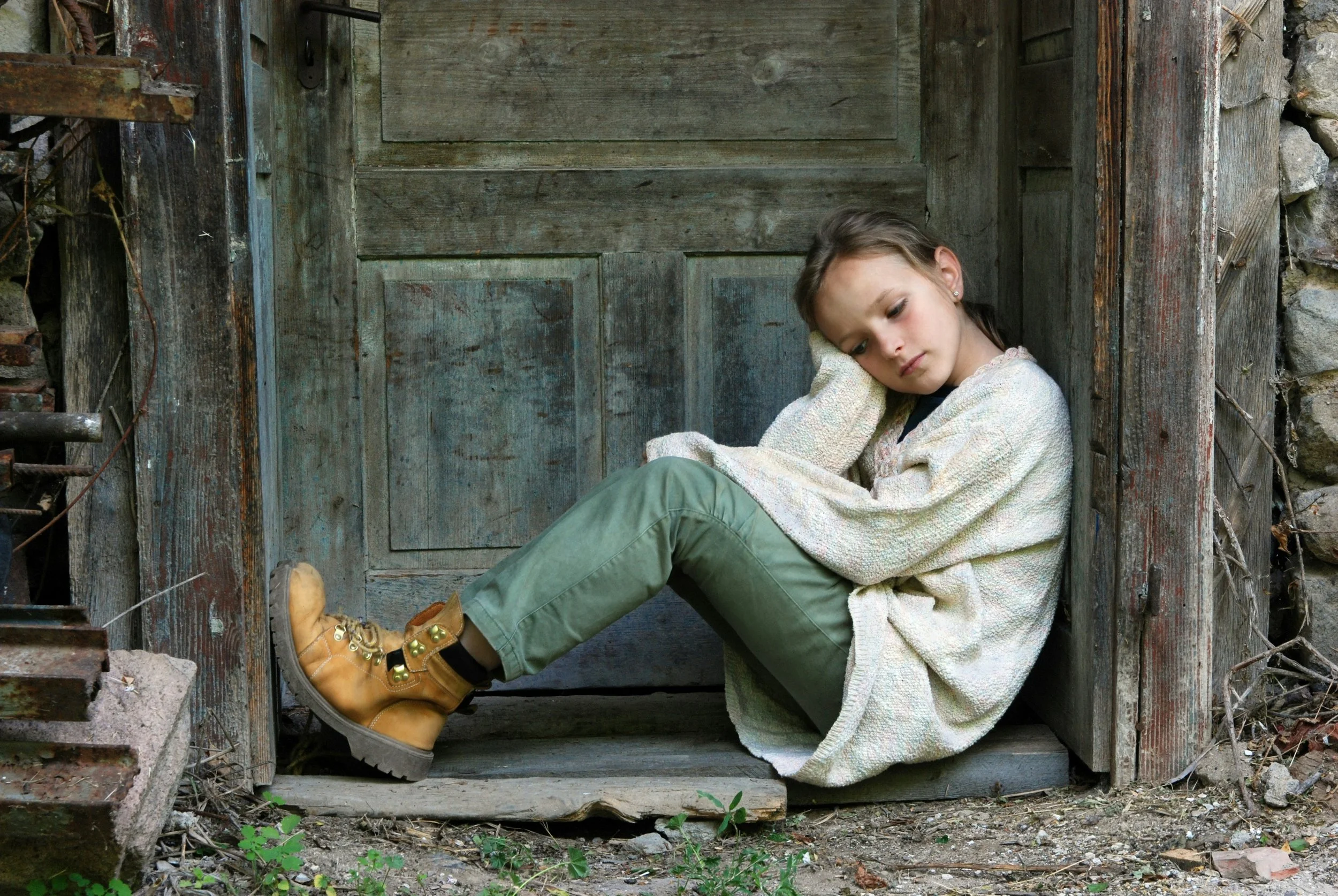 child relaxing by a wood door