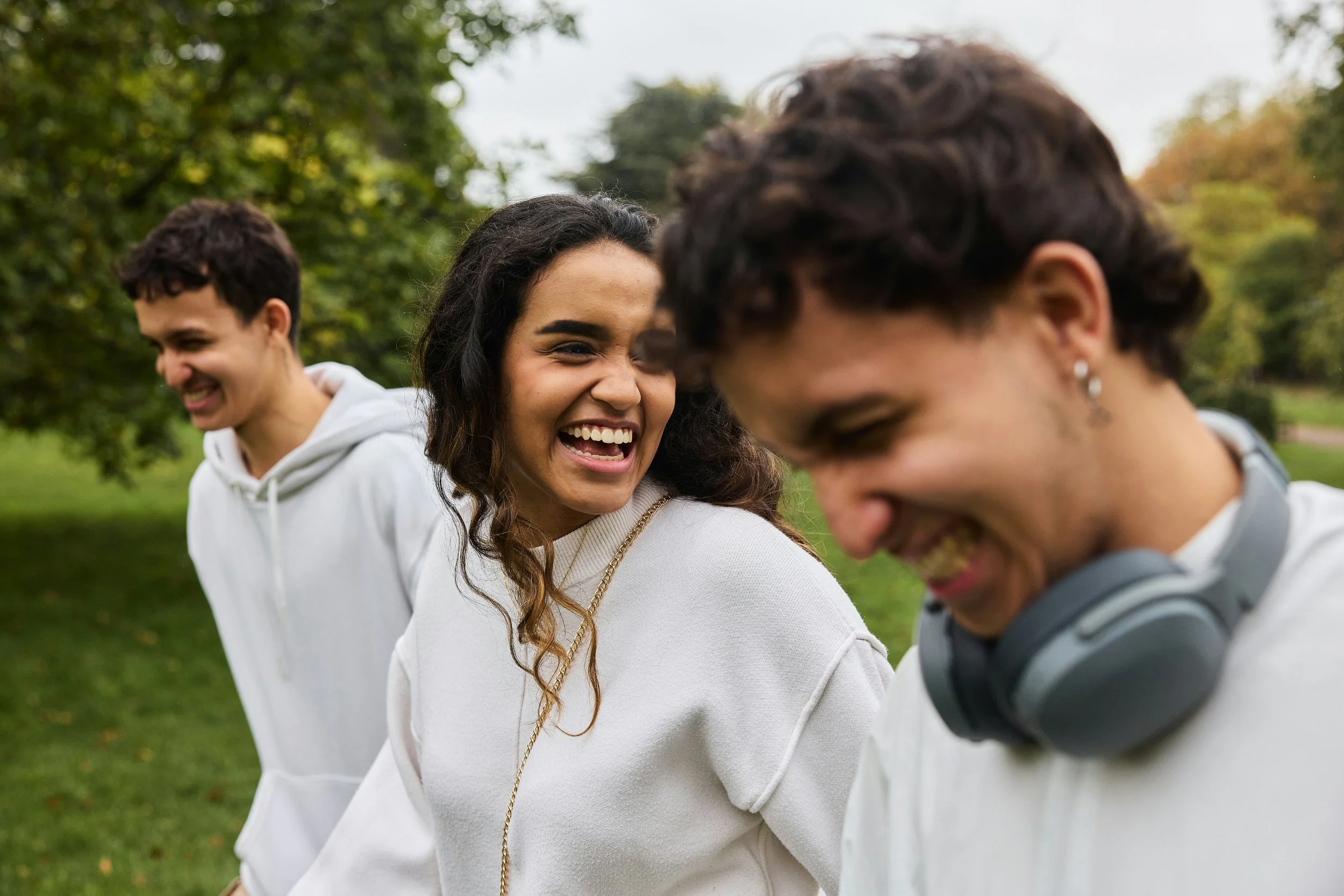 three people smiling while walking