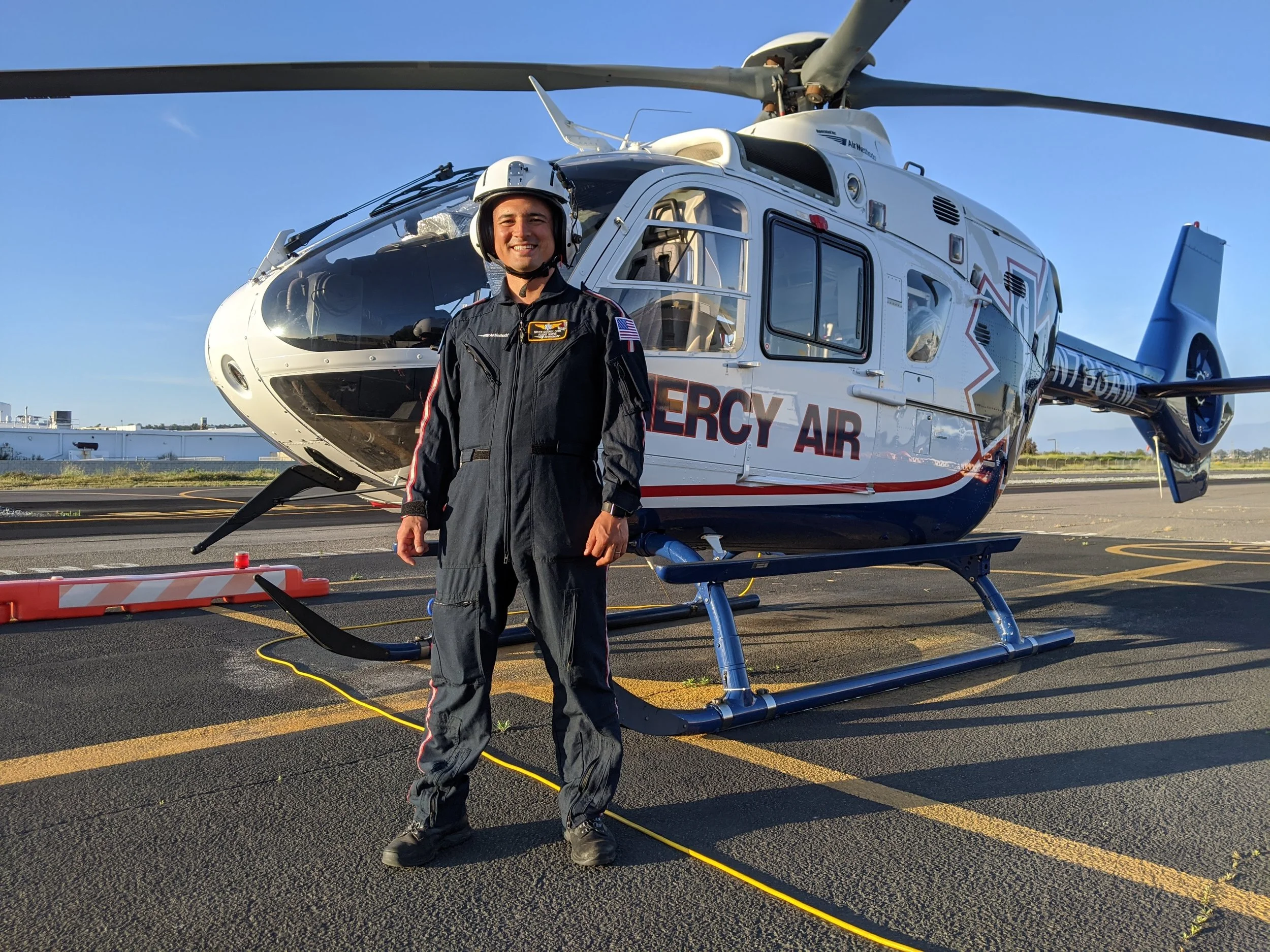 Bryce Gosney PMHNP standing in front of a medevac helicopter representing trauma-informed PTSD care in Ogden Utah