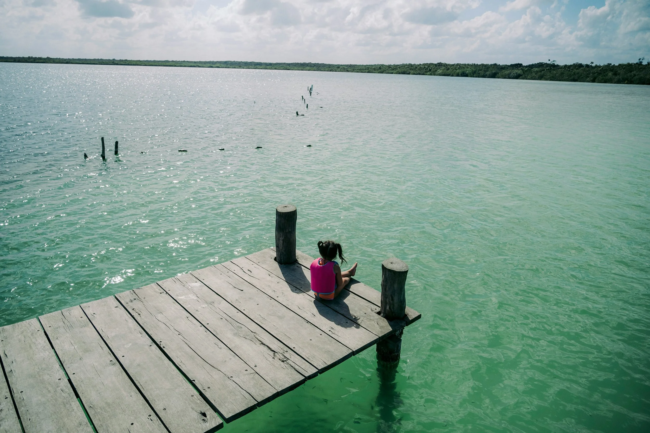 child sitting on a pier