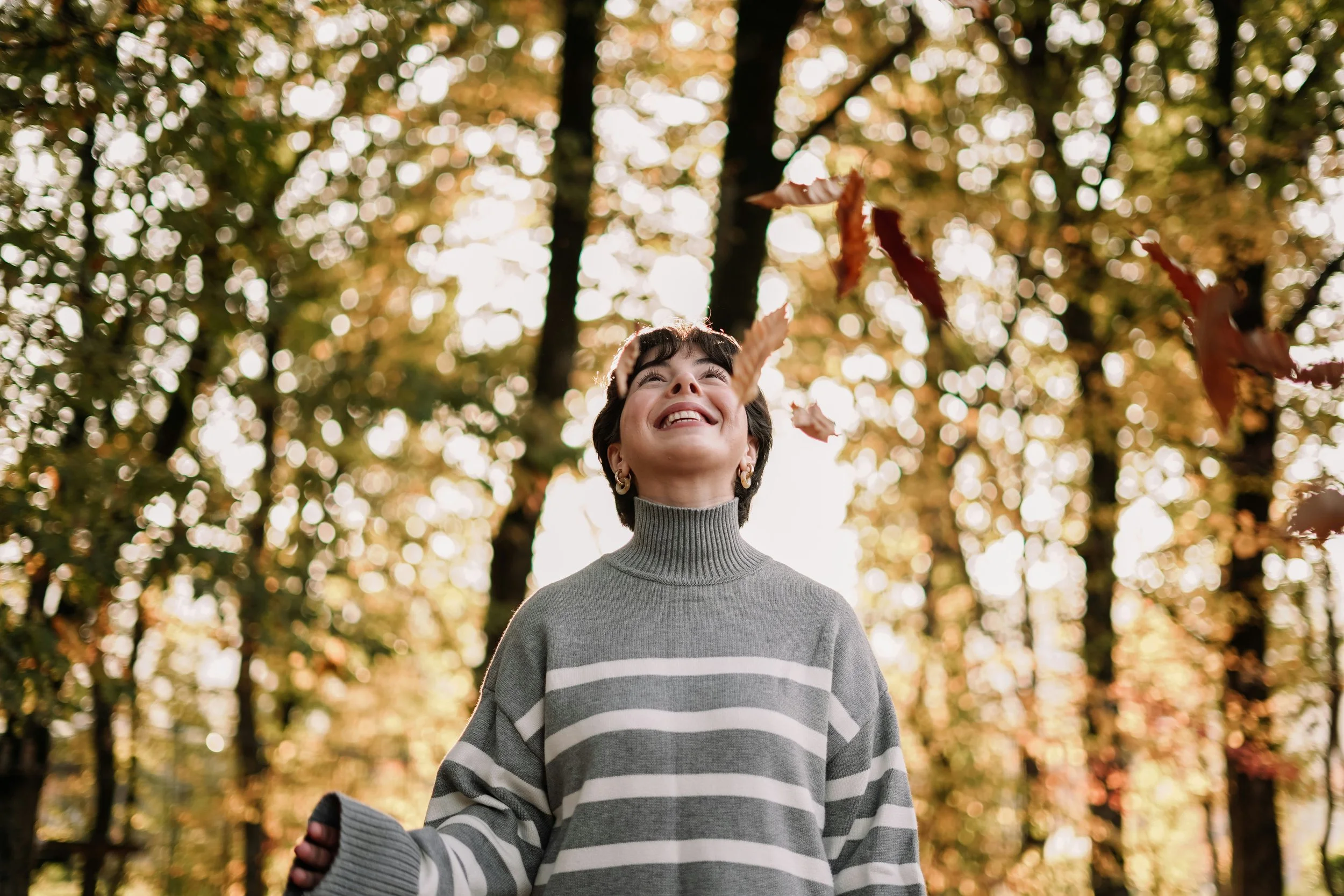 woman standing with falling leaves
