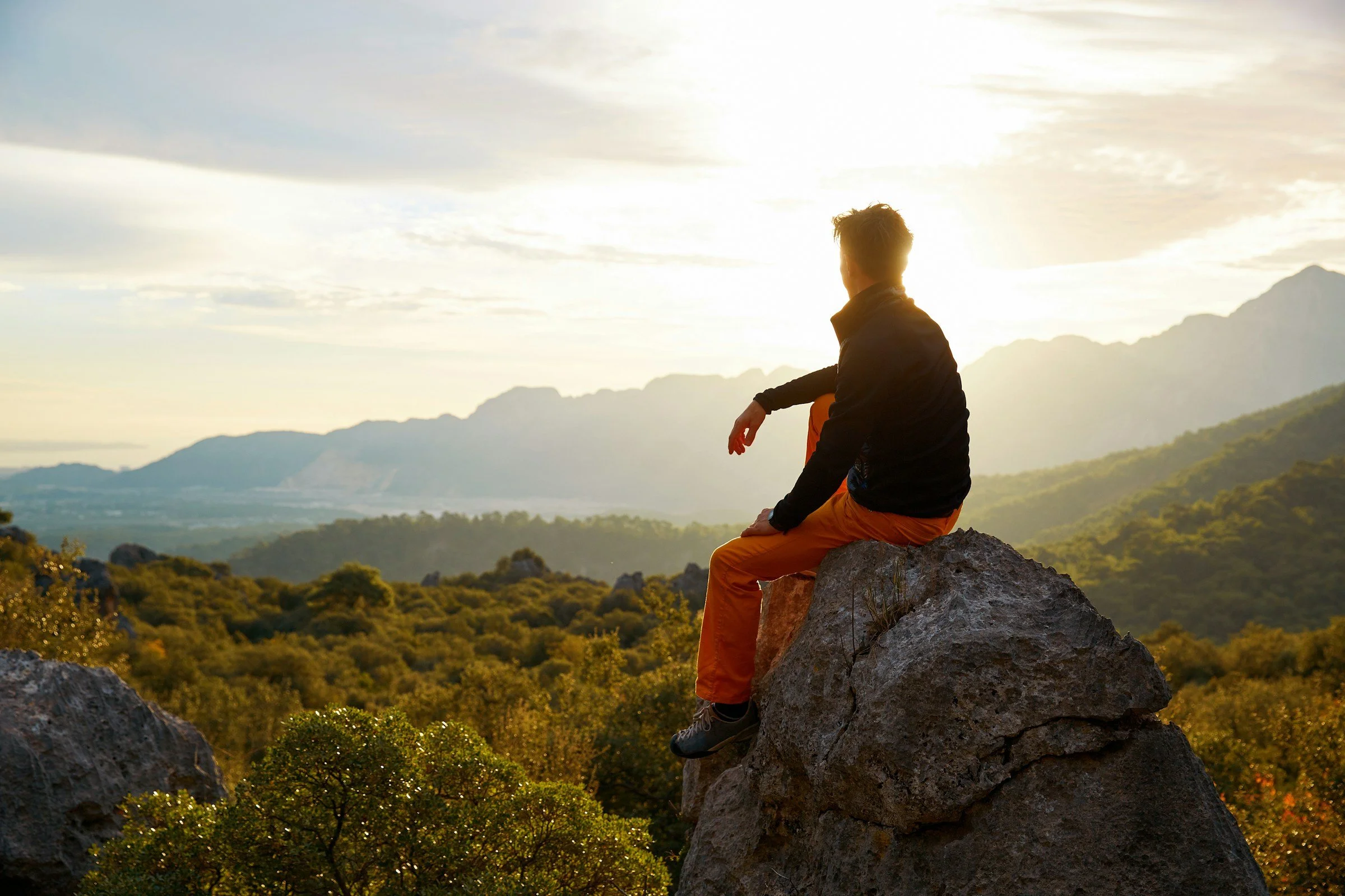 man sitting on a hilltop