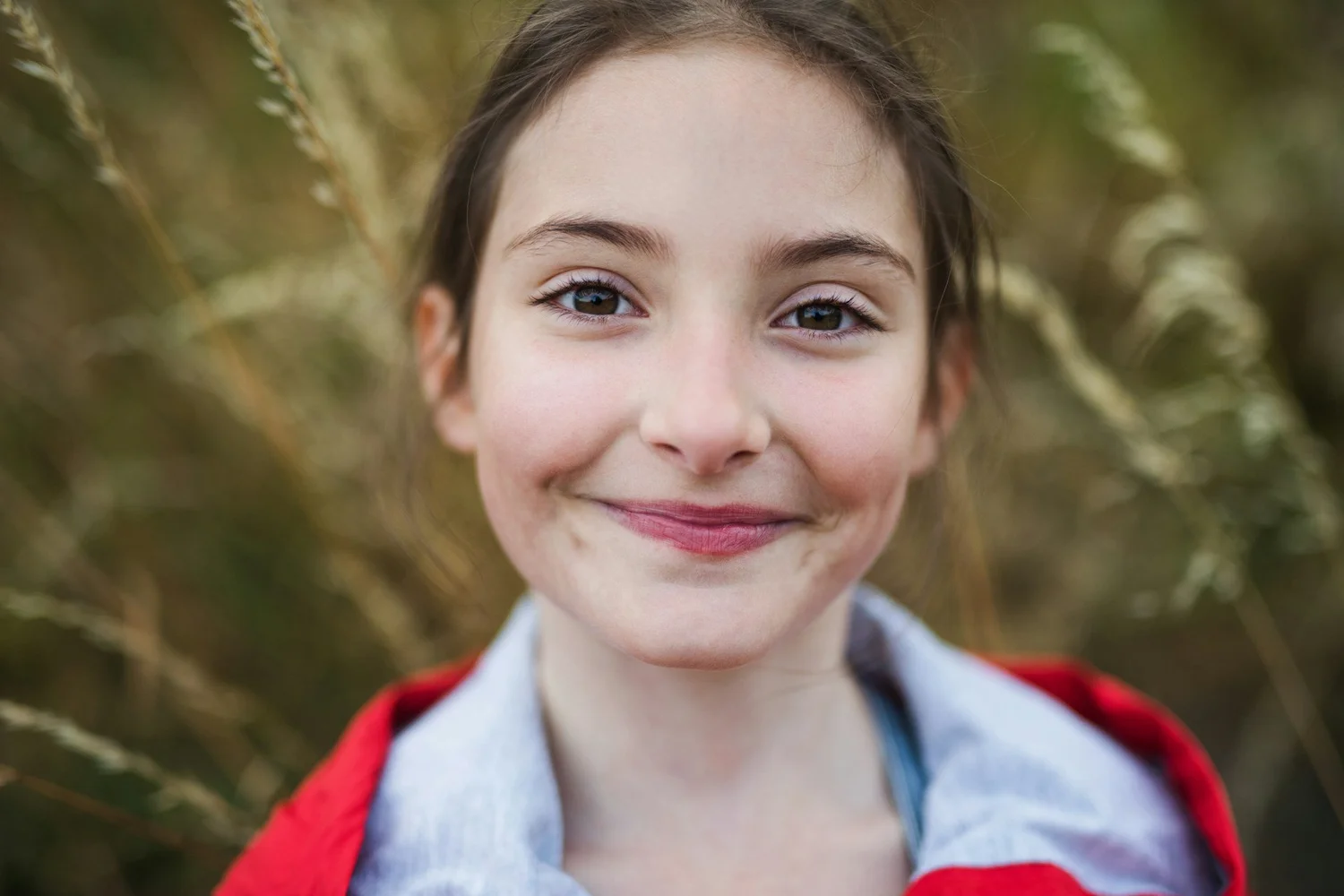 Child smiling in a wheat field representing pediatric anxiety treatment in Ogden Utah