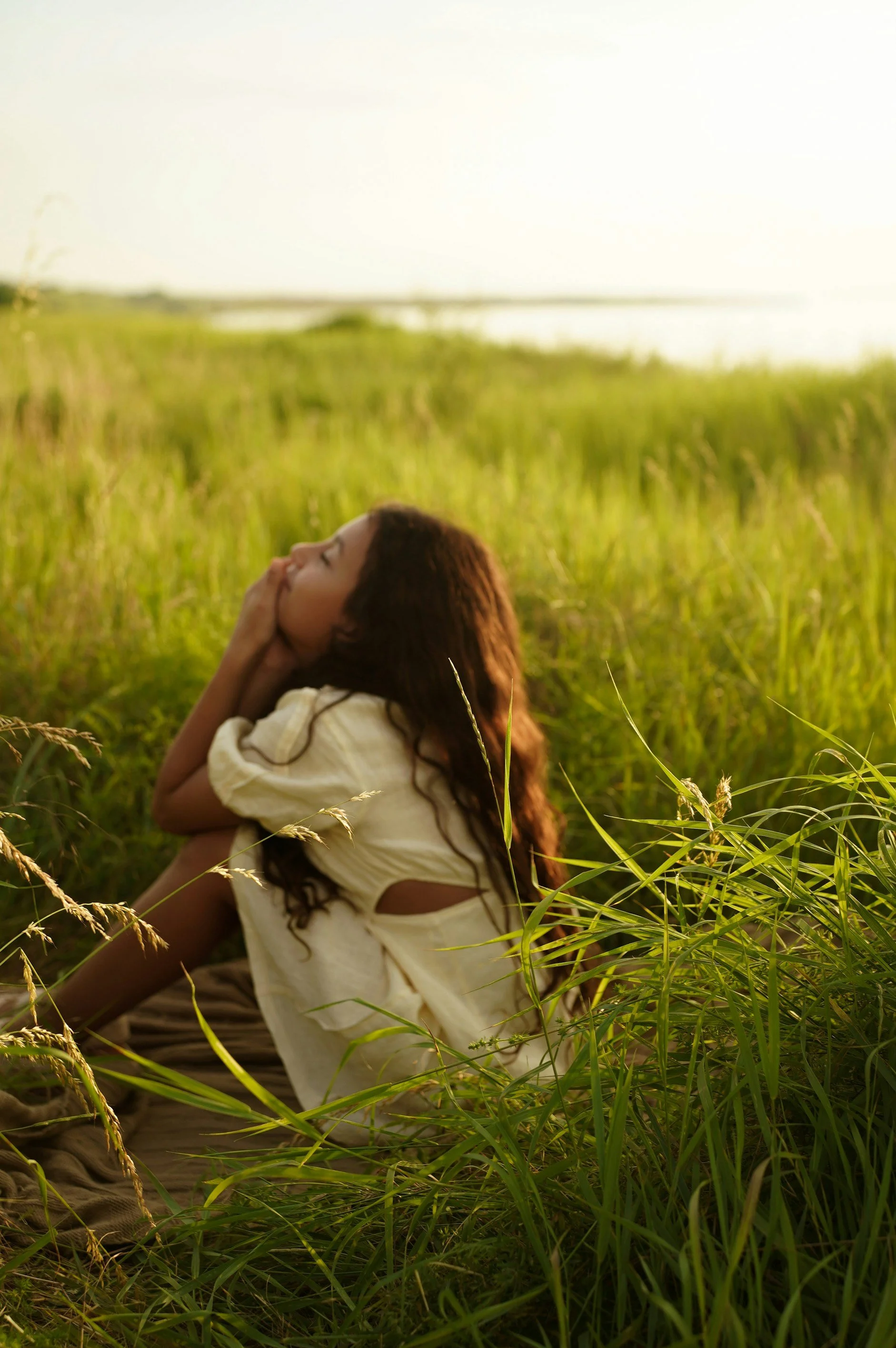 child sitting in a field of grass