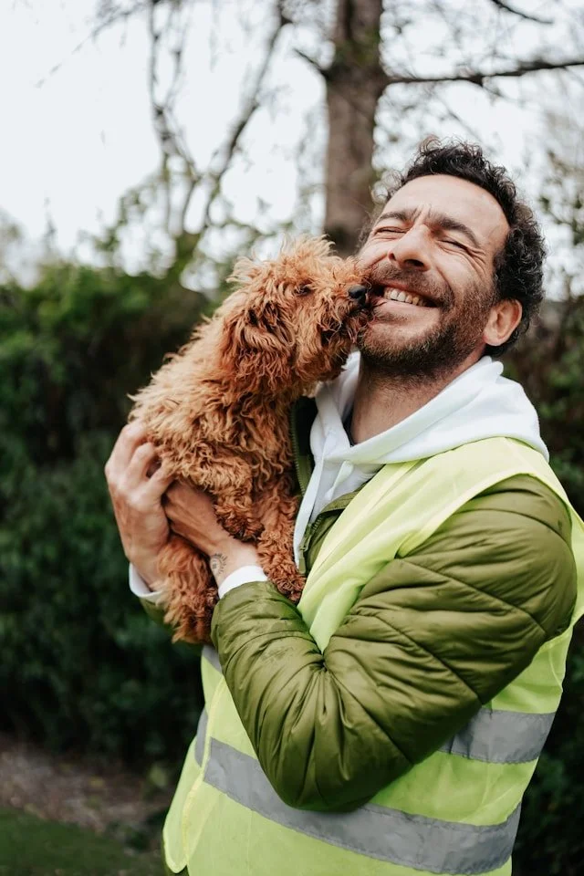 Man having his face licked by a brown dog representing connection and recovery during OCD treatment in Ogden Utah