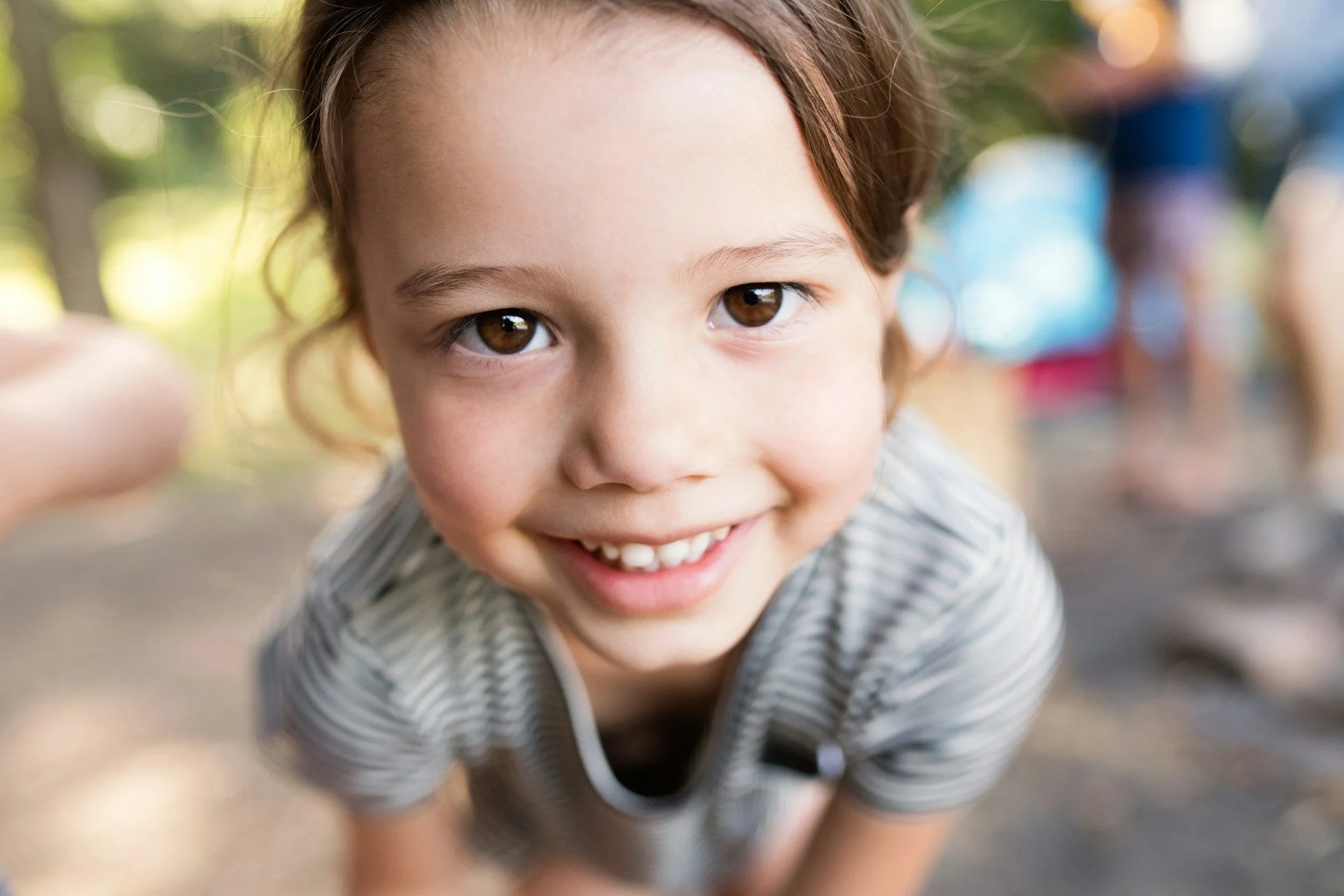 Little girl bending over and smiling confidently after selective mutism treatment in Ogden Utah