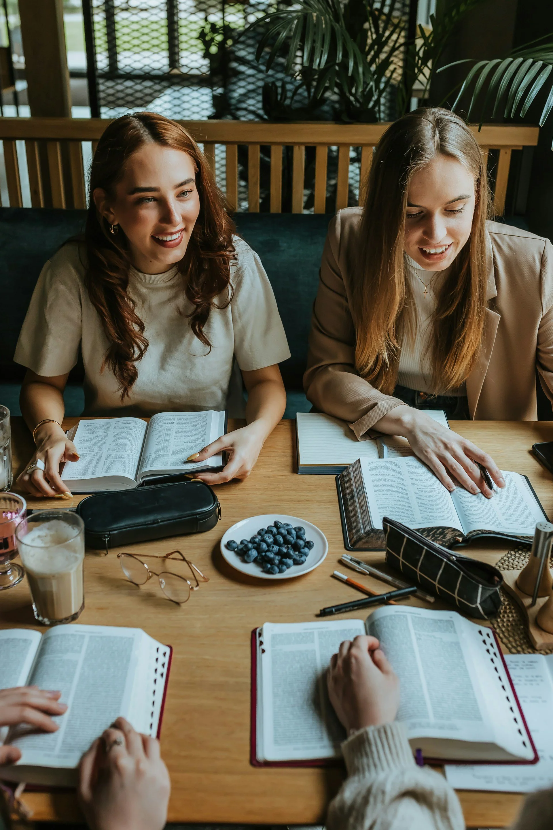 Two women reading together and smiling with improved focus and attention after ADHD treatment in Ogden Utah