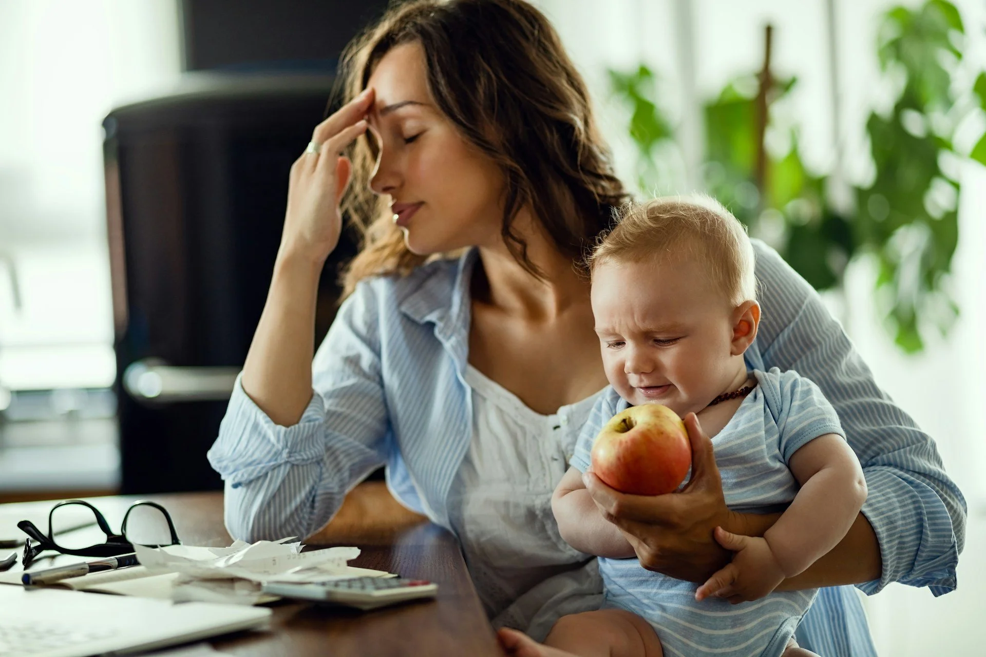 woman holding a baby and an apple