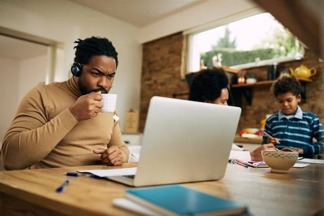 man sipping coffee and working on a laptop