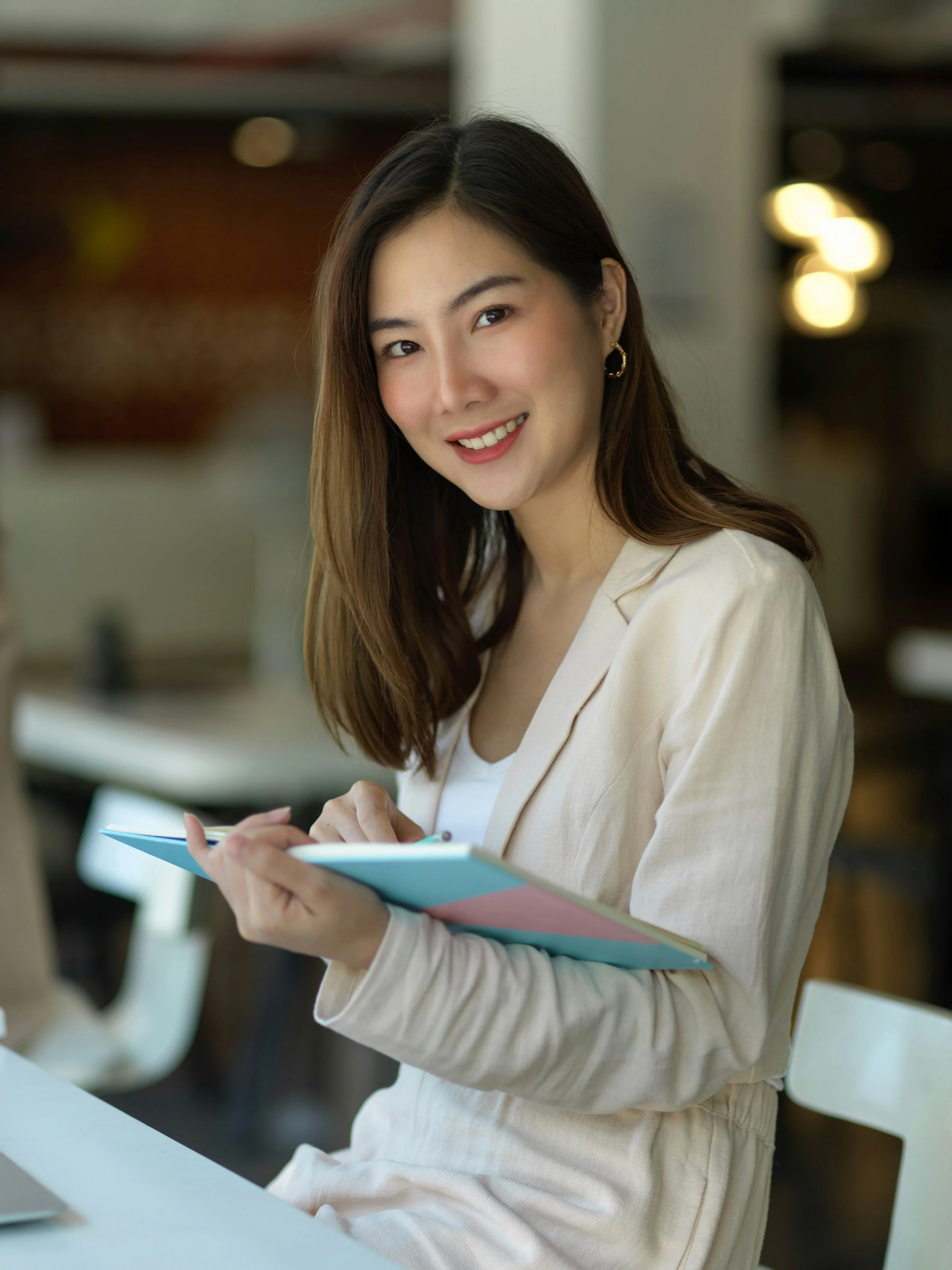 woman smiling and writing in a notebook