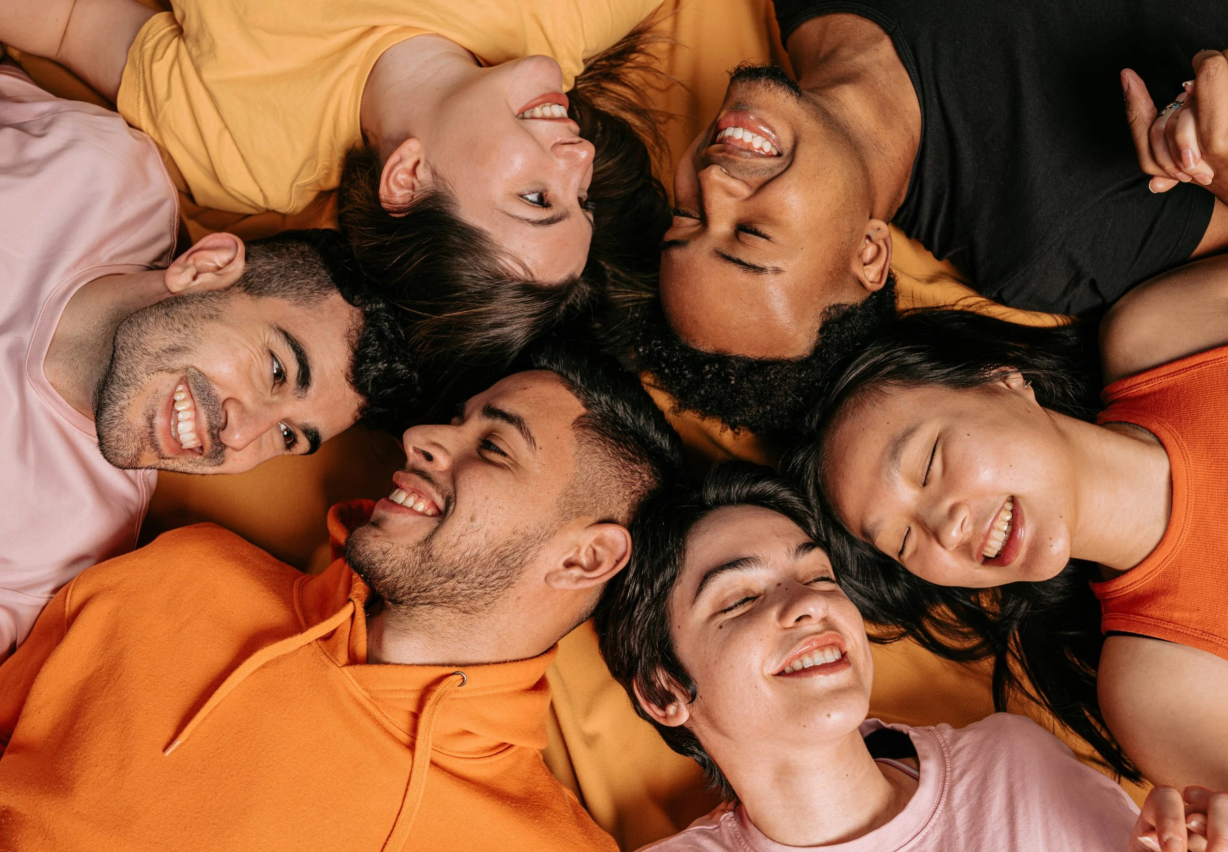 a group of people lying in a circle with smiles