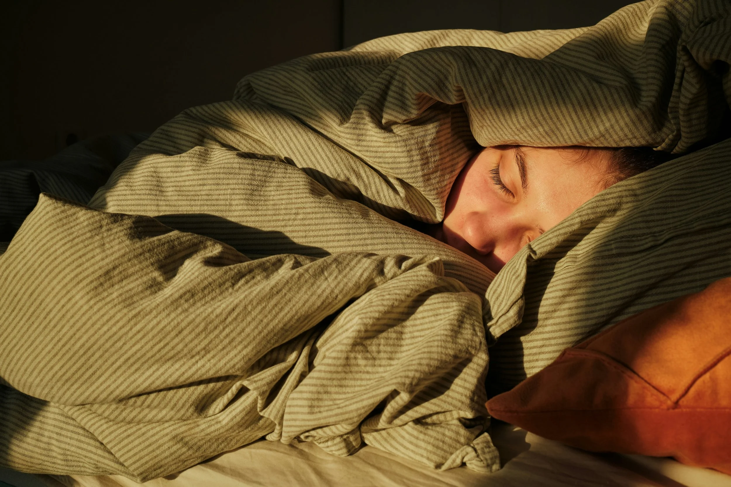 woman sleeping hidden under blanket