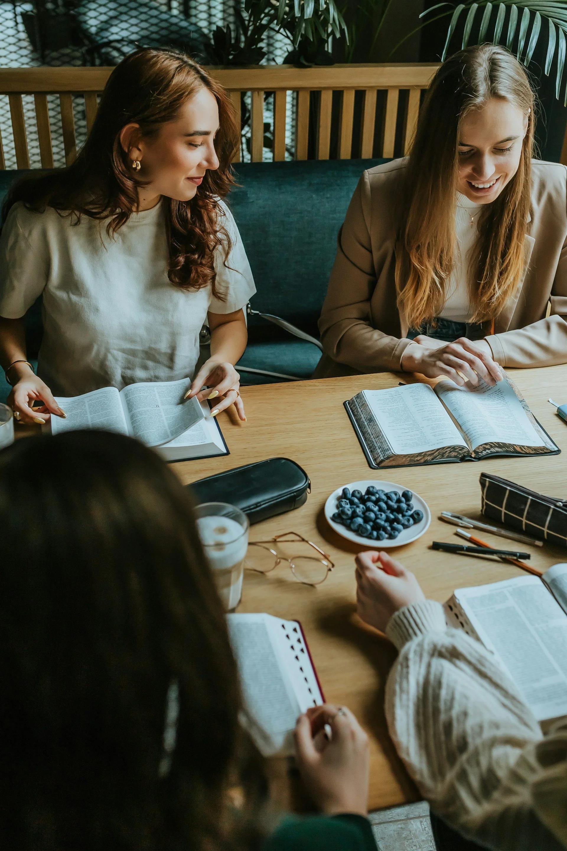 Two women working and reading together at a table with improved focus after OCD treatment in Ogden Utah