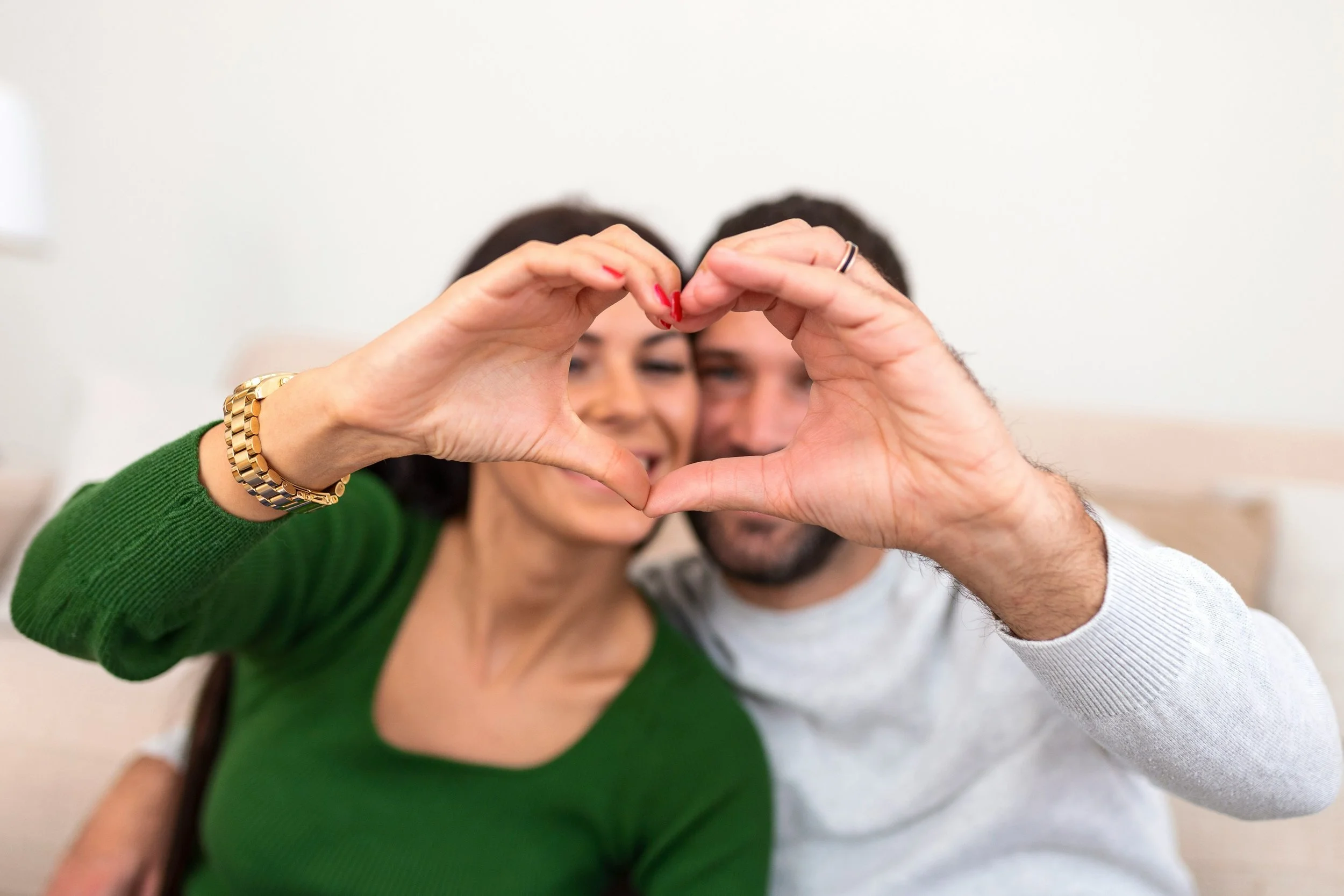 couple making a heart with their hands