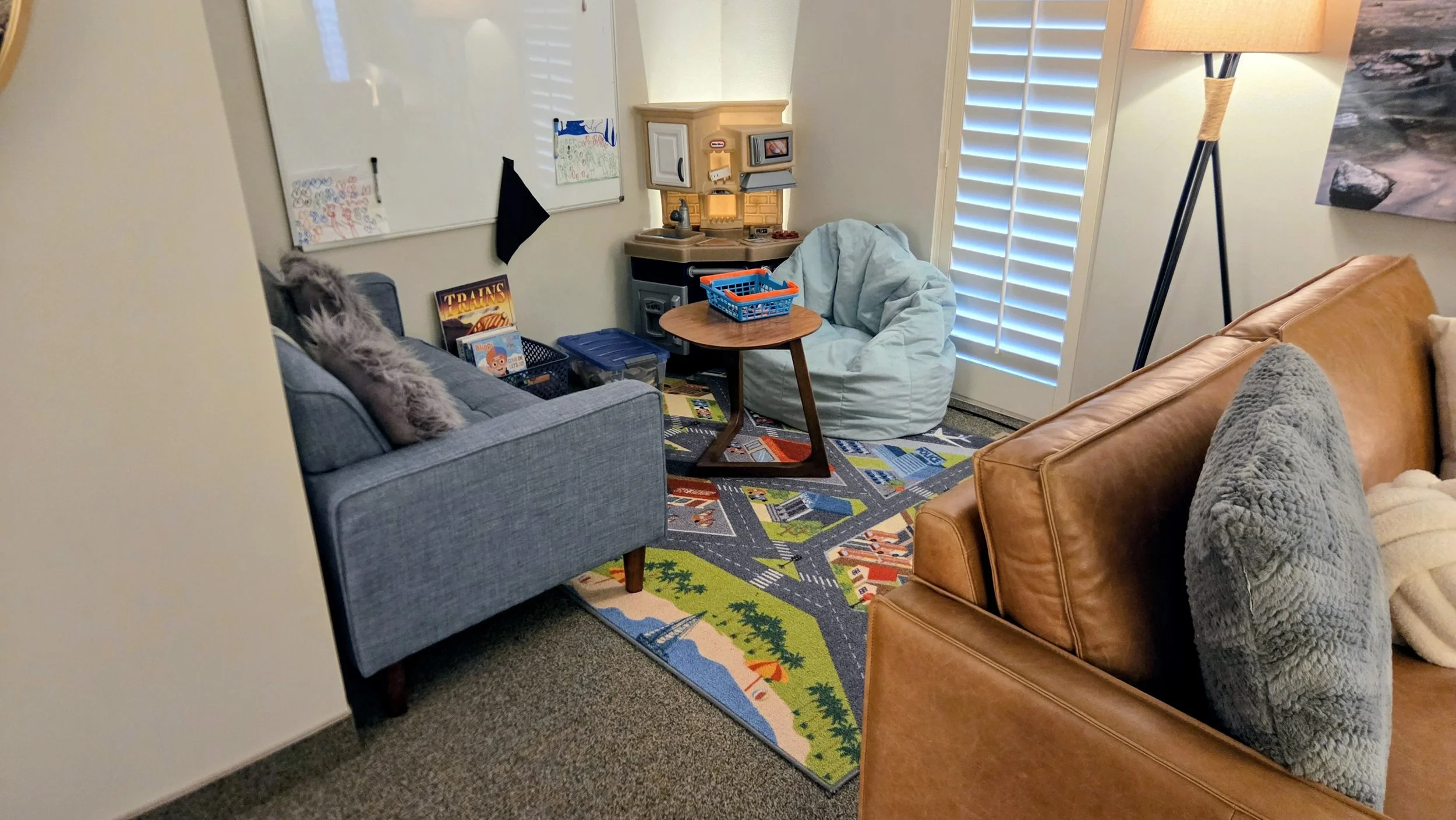 A cozy children's playroom with a colorful road map rug, for kids while families are receiving mental health treatment at Good Day Mental Health in Ogden Utah