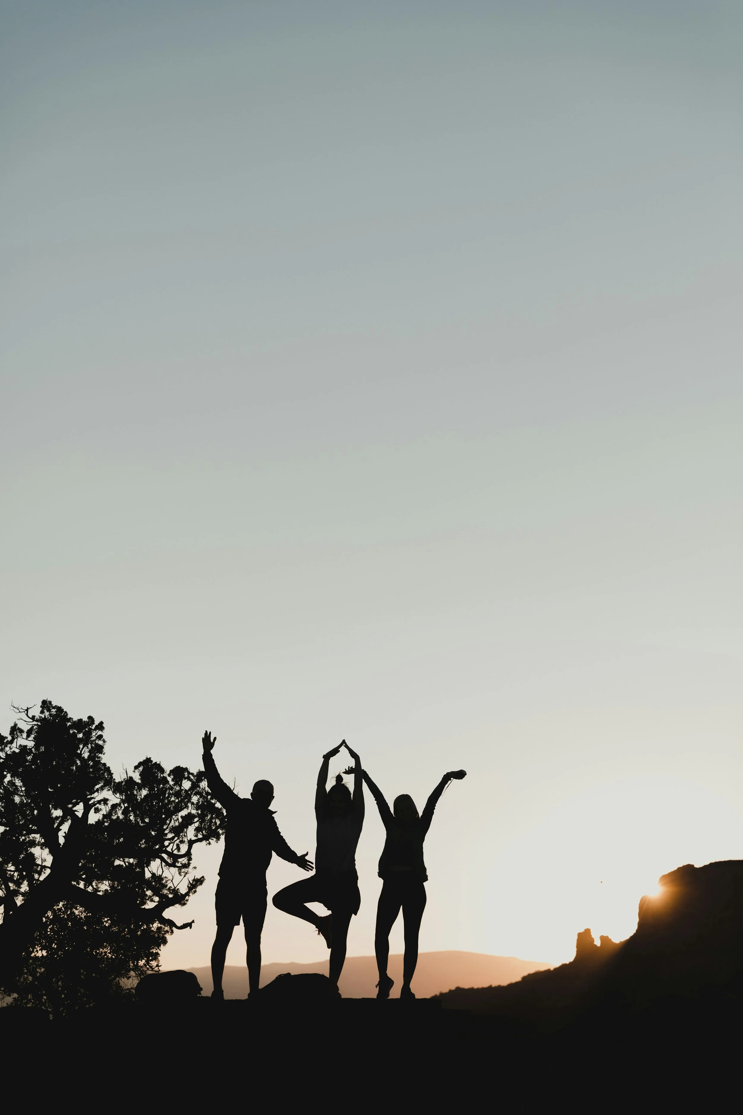 three people backlight by a sunset