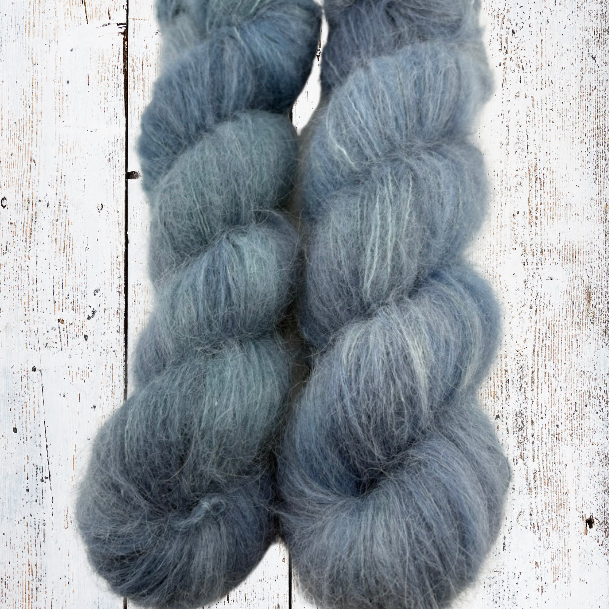 Close‑up of alpaca yarn showing its airy, fuzzy texture and cool blue‑grey shades, perfect for lightweight knitting projects.