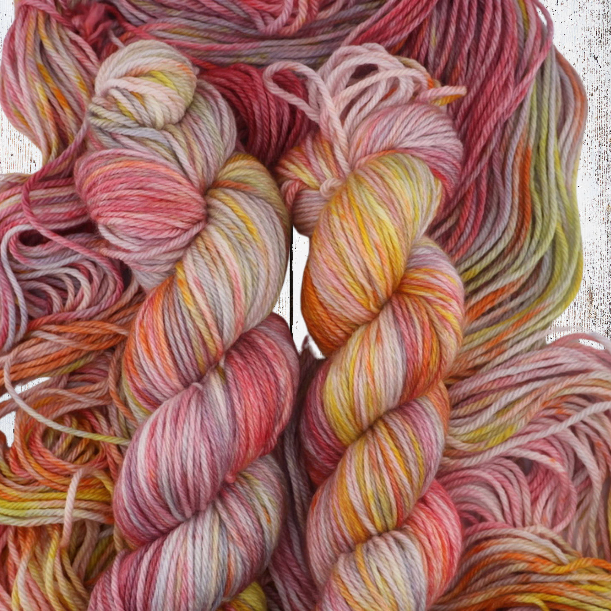 Two bright multicoloured yarn skeins in a basket, shown within a digital gallery interface, featuring warm gradient tones and decorative floral styling