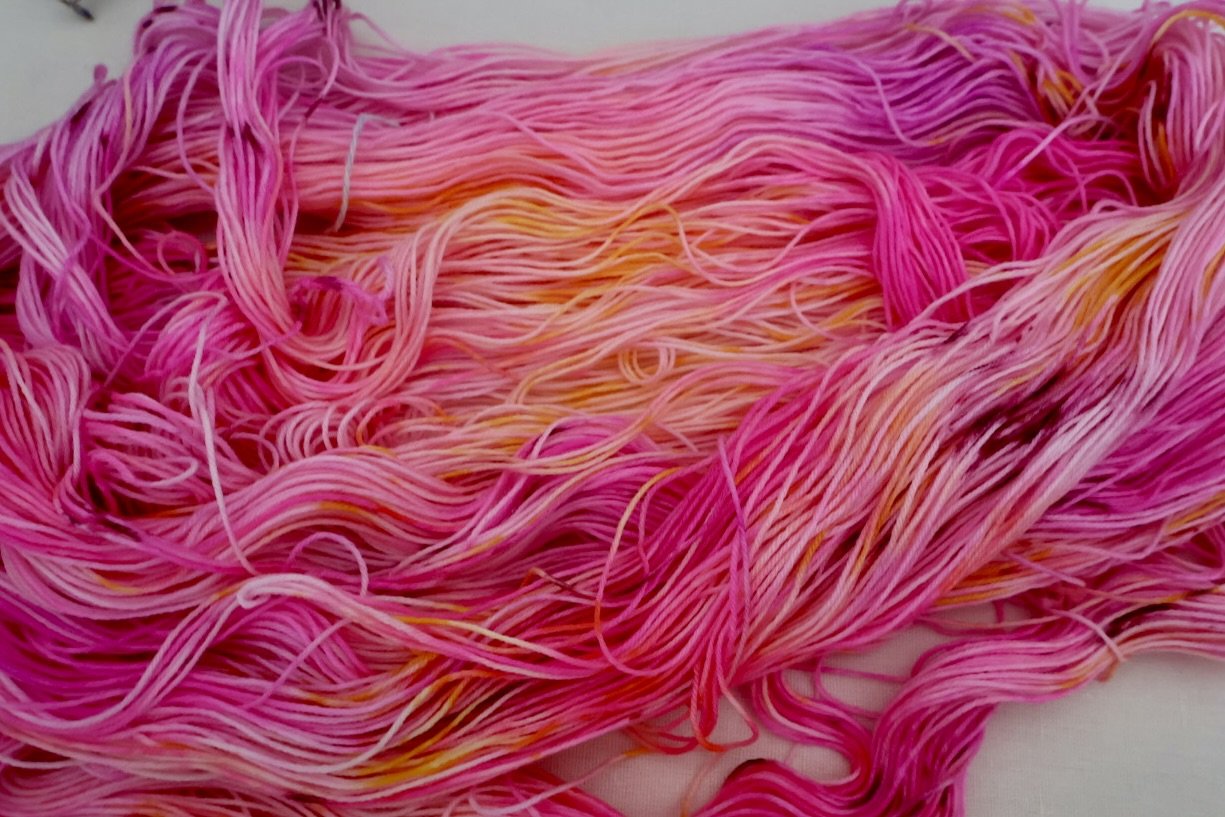 A bold floral palette inspired by Scotland’s botanical gardens. Pink, purple, and golden tones hand‑dyed on a soft merino/nylon 4‑ply base.