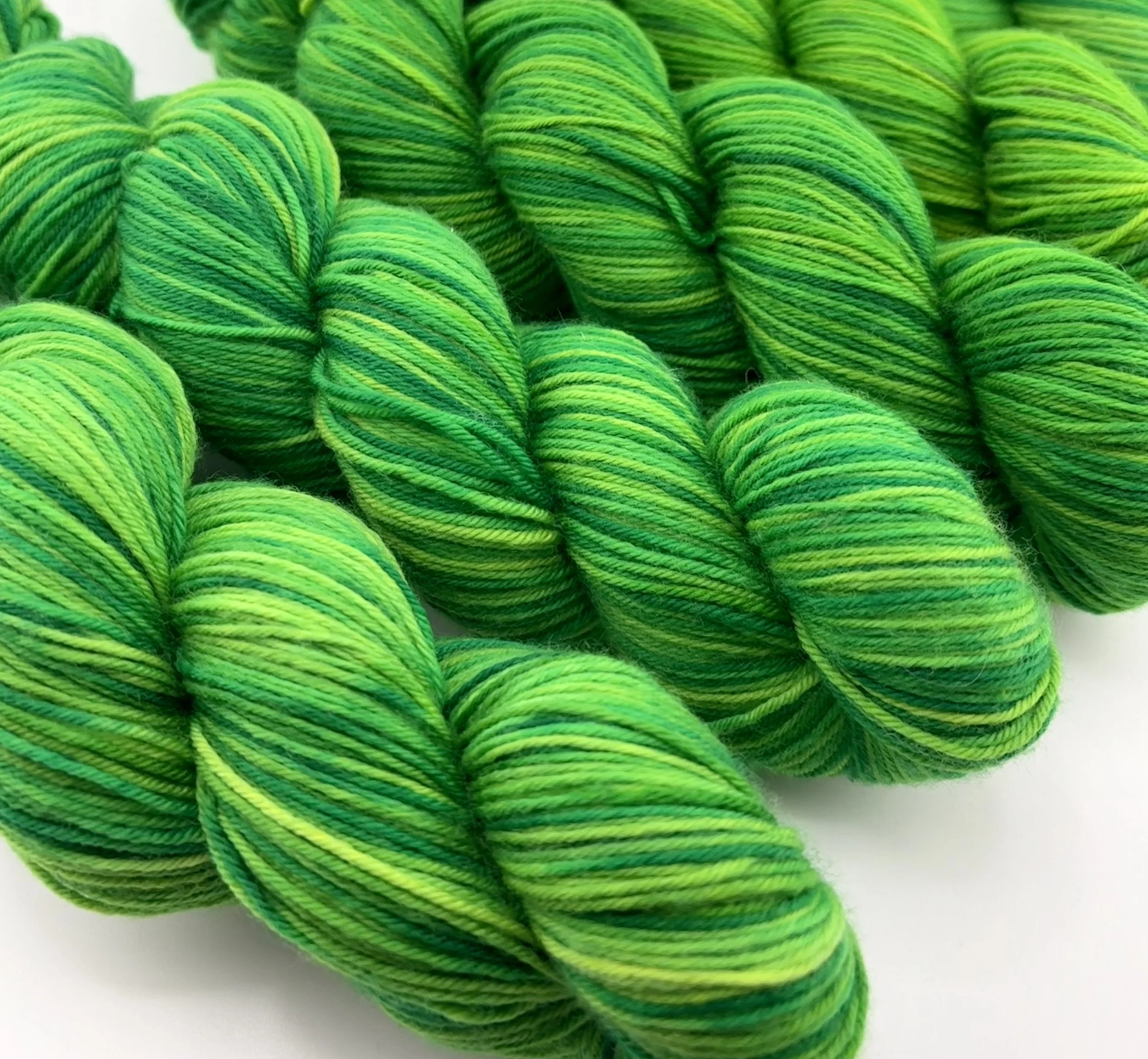 Multiple skeins of green variegated yarn.