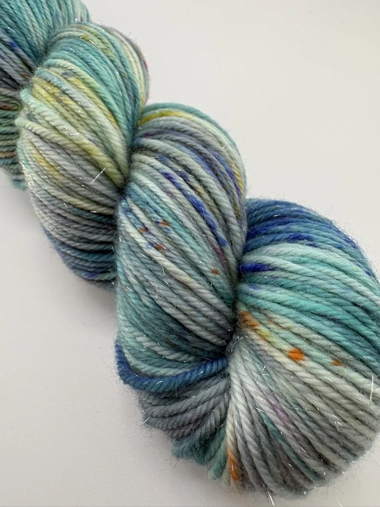 A close up picture of a single  skein of 75/20/5% Merino/Nylon/Stellina Sparkle DK yarn