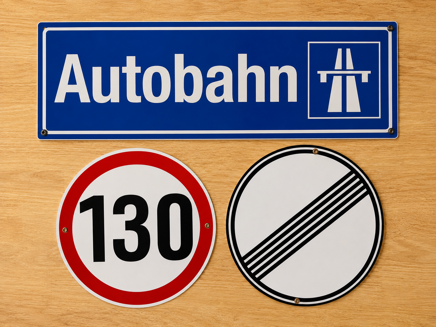 Iconic German Traffic signs including  the word 'Autobahn' and a highway symbol, a speed limit sign of 130, and a no-speed-limit sign with black diagonal lines.