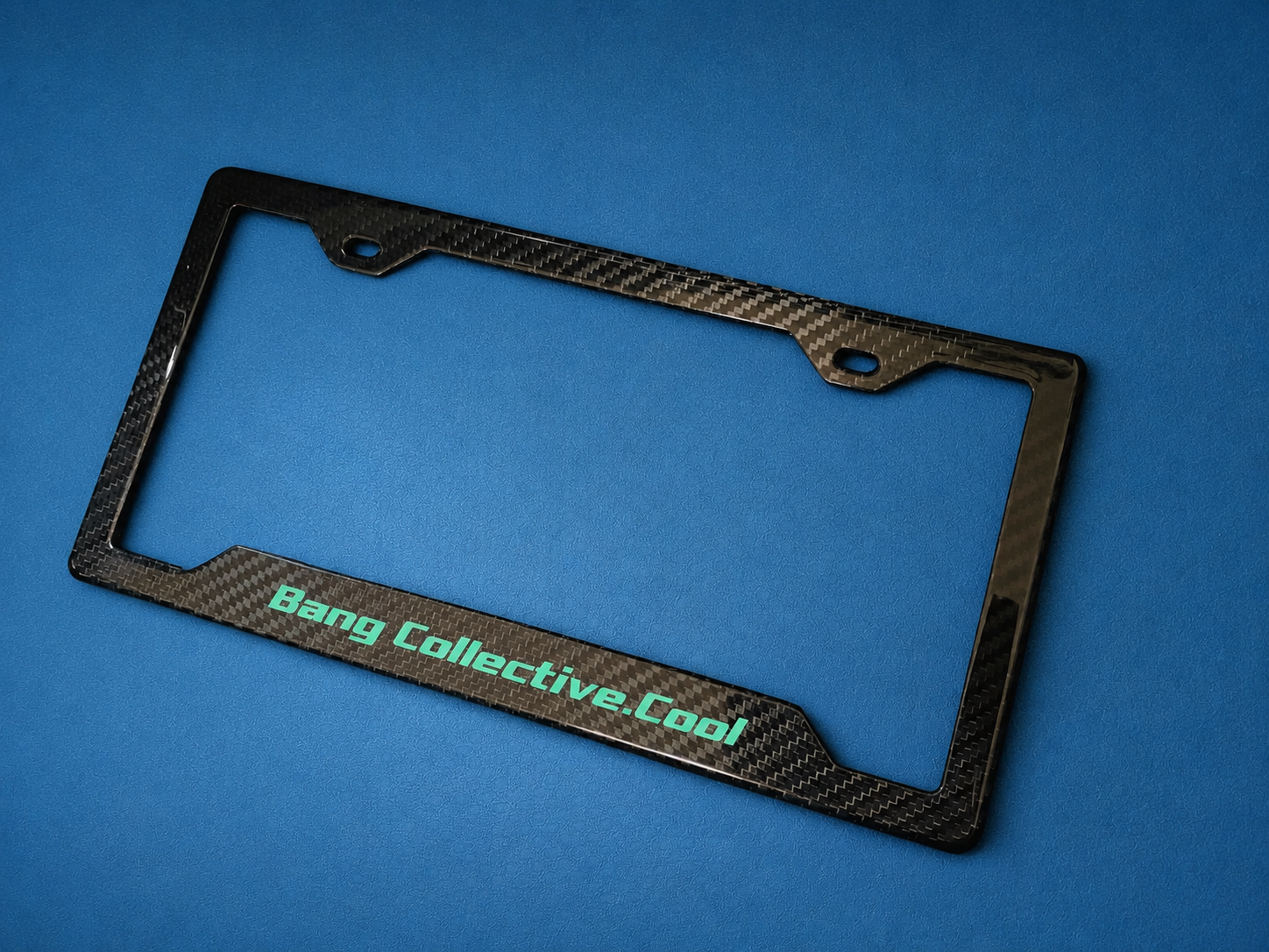 A black carbon fiber license plate frame on a blue background with the text "Bang Collective.Cool" in light blue.