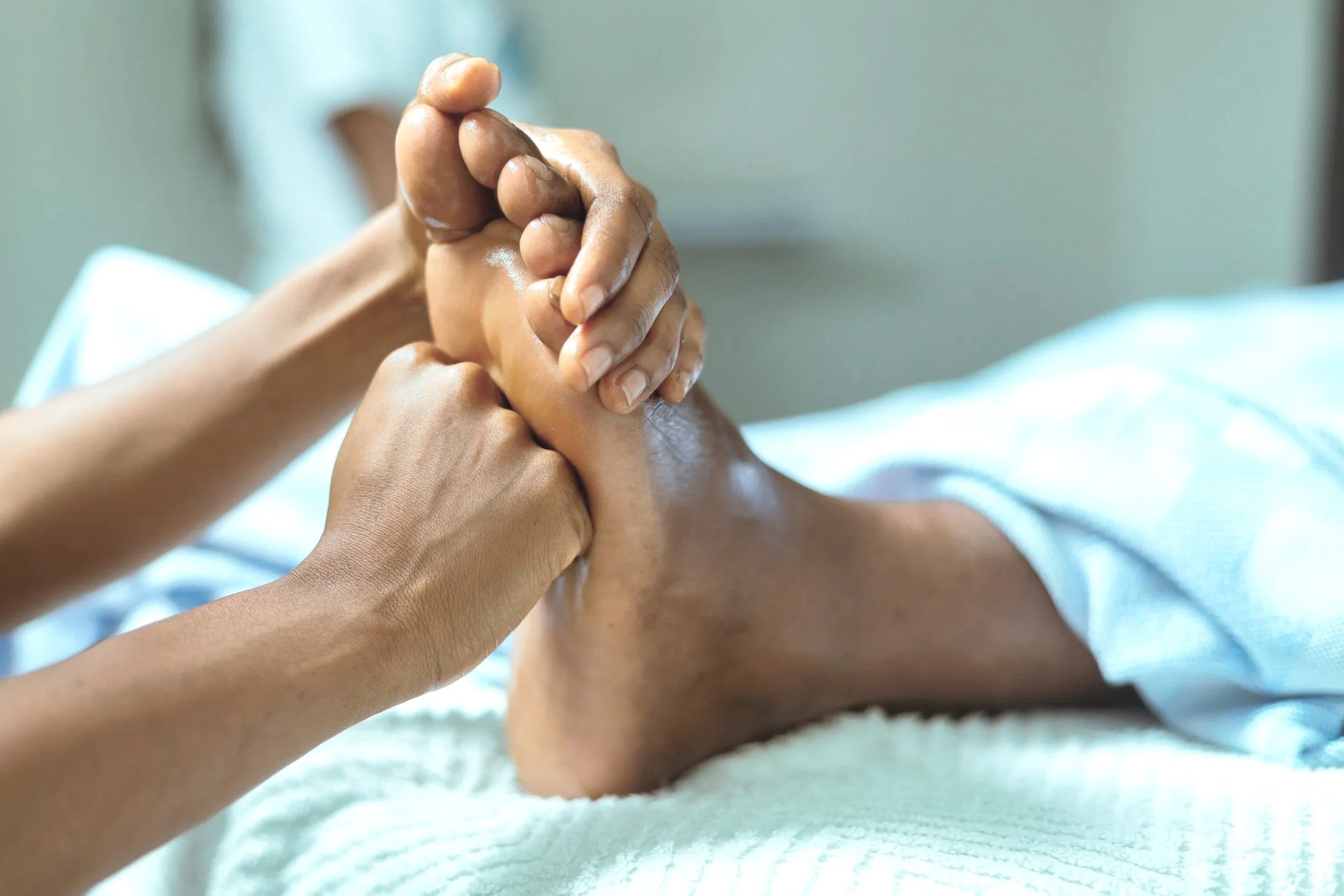 Eine Person erhält eine Fußreflexzonenmassage im Krankenhaus oder in der Klinik.