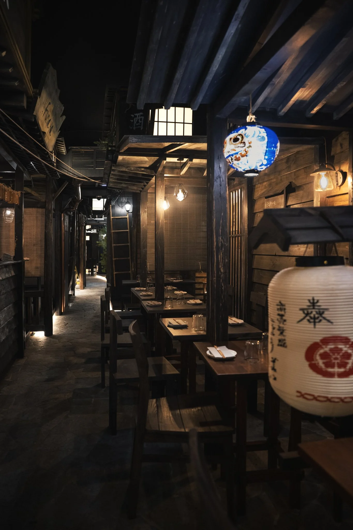 Interno di un ristorante giapponese con lanterne tradizionali e tavoli apparecchiati