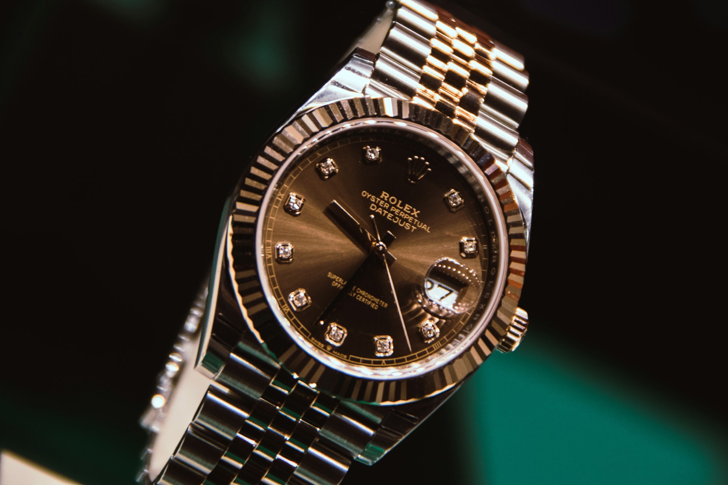 A close-up of a gold and silver Rolex Datejust watch with diamond hour markers and a fluted bezel.